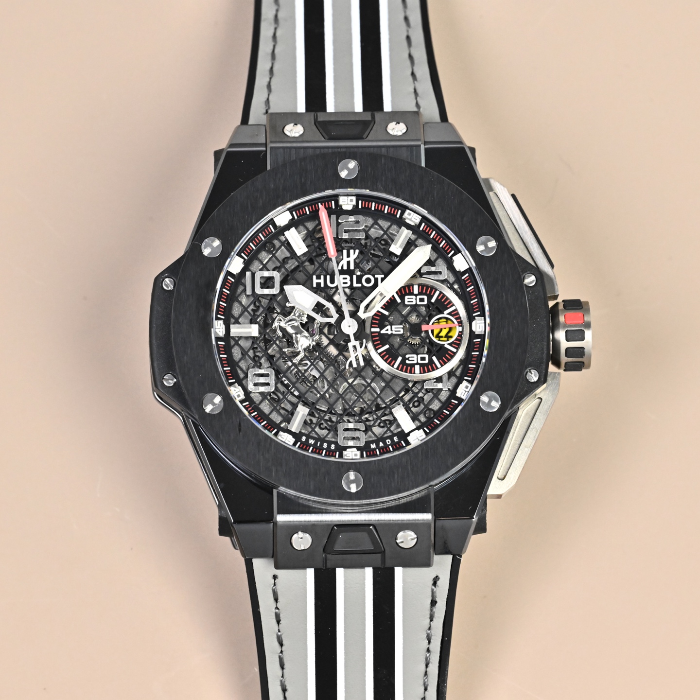 NO:662814,Unified Hublot Big Bang Ferrari Titanium F4 Series Material The case is titanium, which has been brushed and bead blasted, and the side of the case is integrated with black composite resin and carbon fiber sandwich technology. The titanium metal/carbon fiber composite structure of the bezel has both sportiness and strength. The strap is black natural rubber, with a titanium alloy folding clasp, which is comfortable and stable to wear. Movement/Function Equipped with a self-made 7750 modified HUB1241 automatic winding movement, which fully replicates all the original functions.  Design Identity (Ferrari DNA) The instrument panel layout is based on the Ferrari 488 GTB instrument panel, and the 60-second counter on the right is transformed into a 'tachometer'. The Prancing Horse emblem is inlaid on the panel with a three-dimensional Prancing Horse, which is instantly recognizable. The red-embellished timing buttons + quick-release strap system continue the racing-level control experience.,, prada, ferragamo19860909统一 Hublot Big Bang Ferrari Titanium F4 系列 材质 表壳钛金属,经拉丝与微珠喷砂处理,壳侧融入黑色复合树脂与碳纤维夹层工艺. 表圈钛金属 / 碳纤维复合结构,运动感与强度兼备. 表带黑色天然橡胶,搭配钛合金折叠表扣,佩戴舒适稳固. 机芯 / 功能 搭载 自制 7750 改 HUB1241 自动上链机芯,完整复刻原装全部功能. 设计识别（法拉利 DNA） 仪表盘布局借鉴 Ferrari 488 GTB 仪表台,右侧 60 秒计时盘化身“转速表”. 跃马徽记盘面镶嵌立体 Prancing Horse,辨识度一眼即识. 赛车操控感红色点缀计时按钮 + 快拆表带系统,延续赛车级操控体验.,,prada,ferragamo,Watch