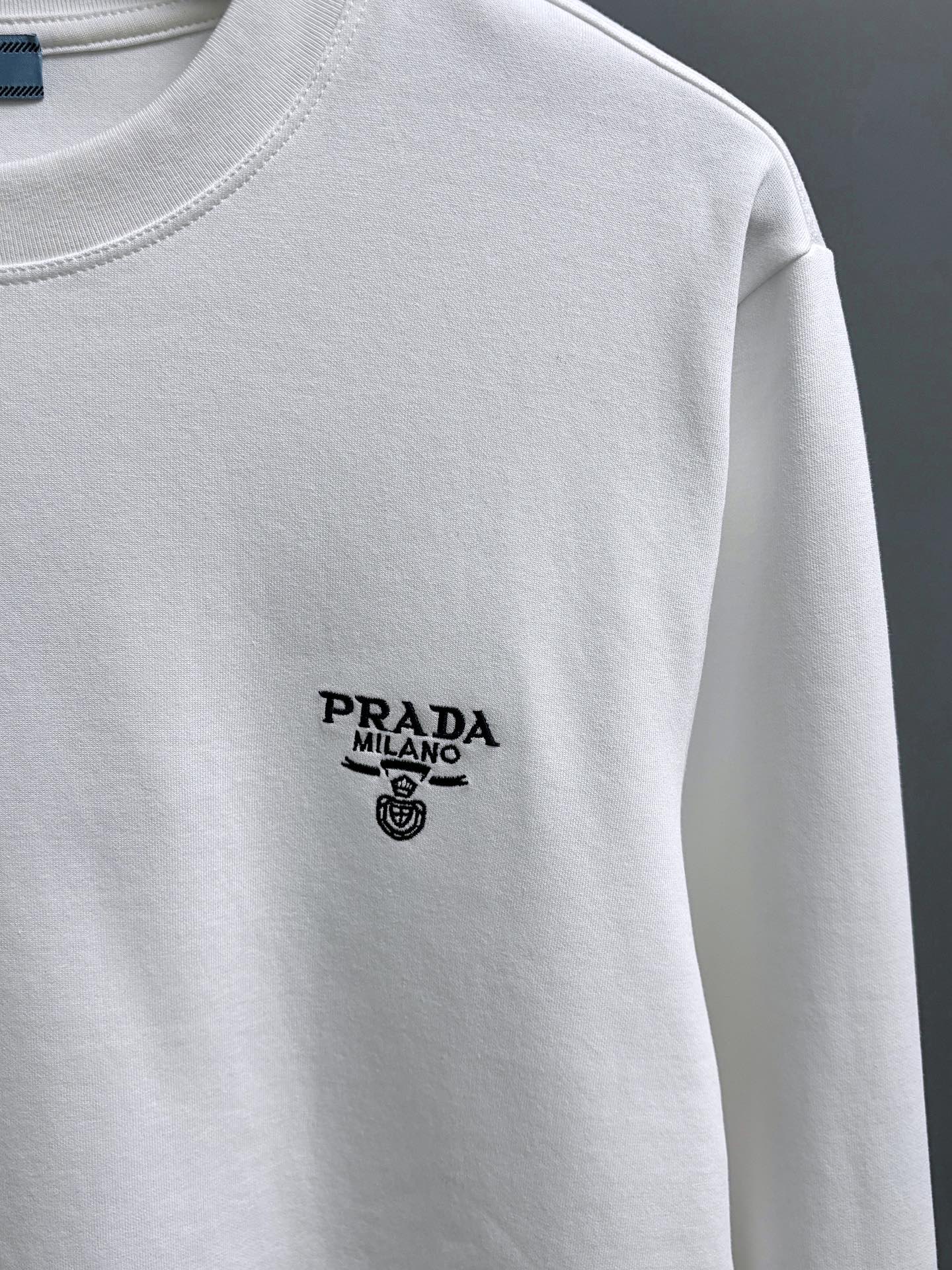 同图不同版，冲🐮货，随意对比 P210 PRADA*
2꯭0꯭2꯭5秋冬款上新 ❤️ 
原⌚️高版本 
普拉达 面料采用320克高密度莫代尔长绒棉 不变形 不缩水 
工艺介绍：双线走位 胸口prada采用进口万针精密梵文小刺绣🪡
颜色：白色
SIZE：M-3XL