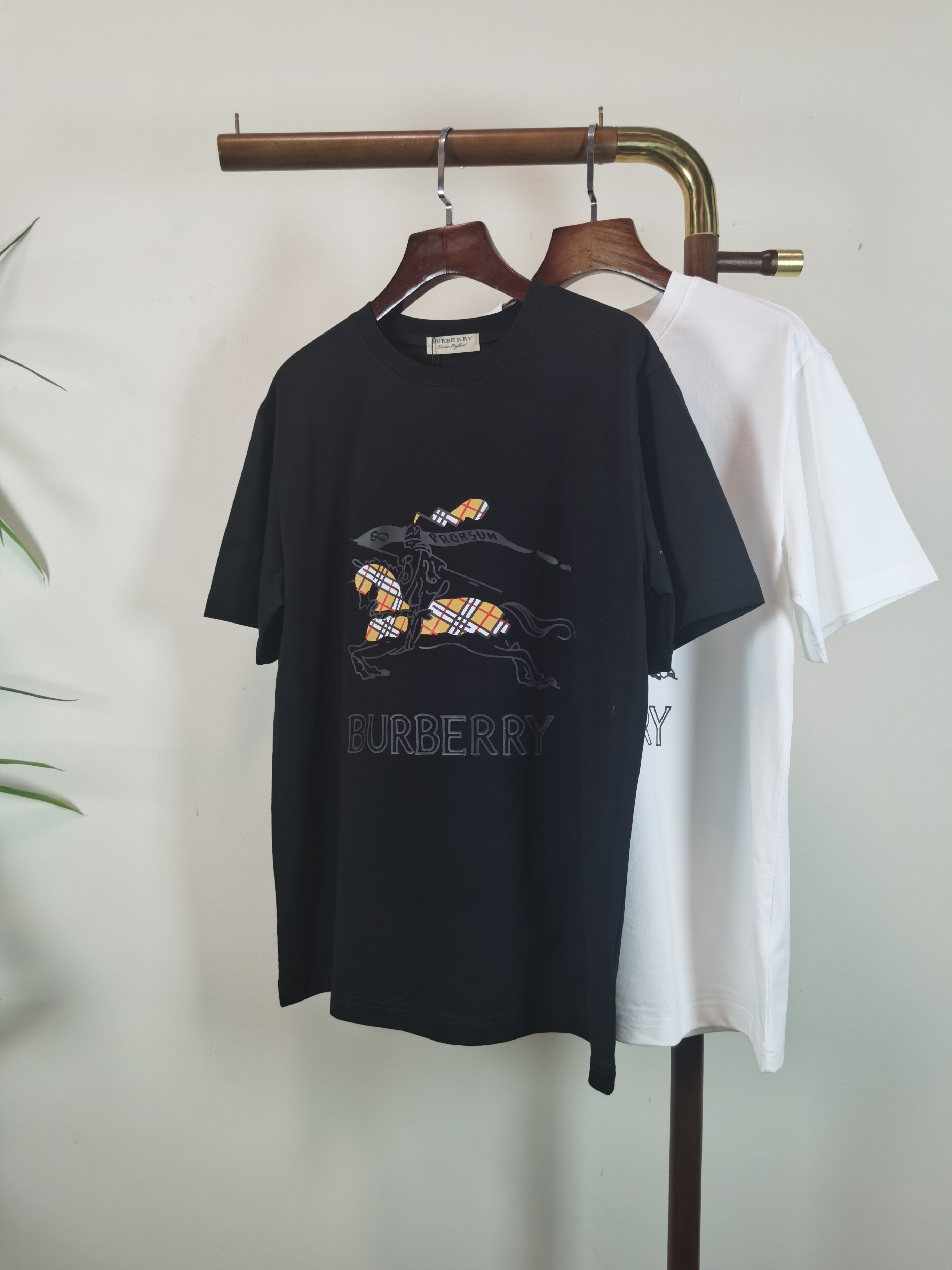 NO:849354,BURBERRY 2026 new printed round neck short-sleeved T-shirt is available for pre-sale!  On sale on overseas official website!  Made of pure cotton double yarn fabric, it feels soft and delicate, the color and gloss are super positive, and the upper body is comfortable and breathable!  Customized threads on the neckline, precision double-needle patchwork, through-shoulder zipper chain bottom, durable and non-deformable, with first-class texture!  This classic round-neck T-shirt is decorated with a highly recognizable logo print on the chest. The three-dimensional and fine detail processing injects a casual charm into the whole, casual and natural, and highly recognizable!  Produced by a large factory, with fine workmanship and complete three standards!  Classic round neck basic model, the version is quite wide and full!  The upper body is fashionable, relaxed and stylish, and the atmosphere is instantly filled!  Same style for men and women!  Size S-2XL Color black white,,burberry,burberry,T-shirt,tees,t-shirt,19860909BURBERRY 巴宝莉 2026新款印花圆领短袖T恤预售出货！ 海外官网在售！ 采用纯棉双纱面料,手感柔软细腻,颜色光泽度都超正,上身舒适透气！领口定织螺纹,精密双针拼缝,通肩拉锁链底耐穿不变形,质感一流！ 这款经典的圆领 T 恤胸前饰有高辨识度的logo印花,立体精细的细节处理,为整体注入一分闲适韵味,休闲自然,超高辨识度！ 大厂出品,做工精细,三标齐全！ 经典圆领基础款,版型挺阔饱满！ 上身时髦 轻松有格调 氛围感一下子拉满！ 男女同款！ 码数S-2XL 颜色黑色 白色,,burberry,burberry,T-shirt,tees，t-shirt,,Men's clothing