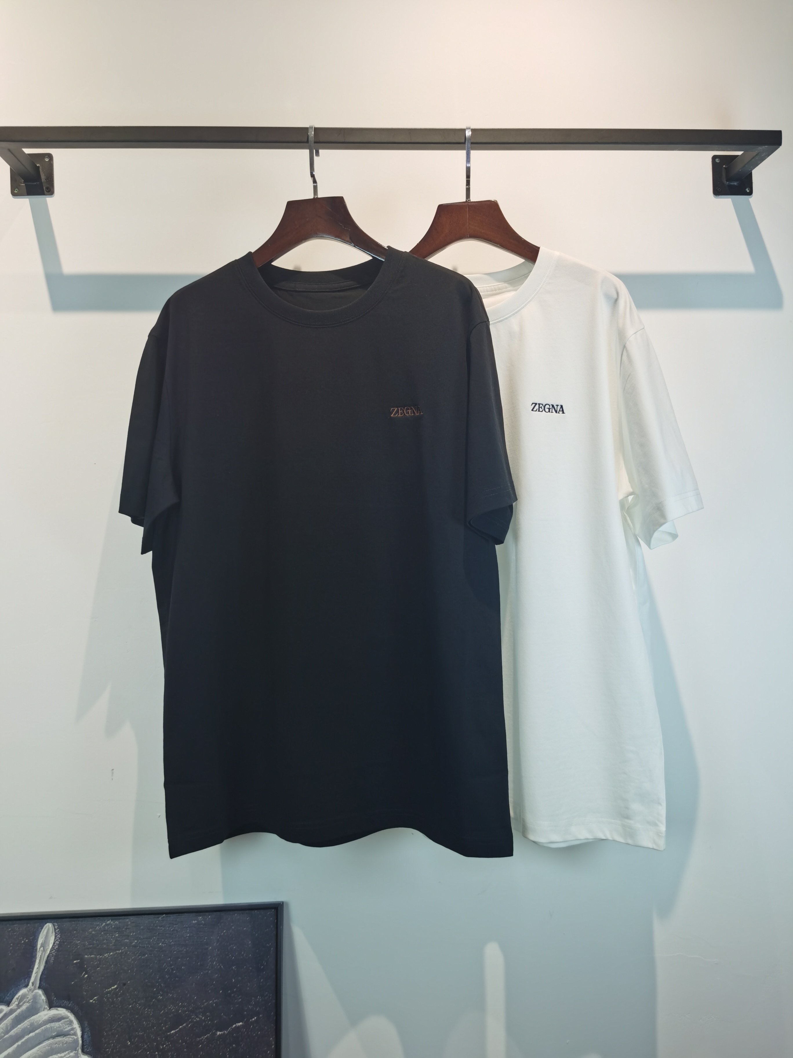 NO:847672,ZEGNA 2026 new embroidered short-sleeved T-shirt is on sale for pre-sale!  On sale on overseas official website!  Made of pure cotton double yarn fabric, it feels soft and delicate, the color and gloss are super positive, and the upper body is comfortable and breathable!  Customized threads on the neckline, precision double-needle patchwork, through-shoulder zipper chain bottom, durable and non-deformable, with first-class texture!  This classic round-neck T-shirt is decorated with a highly recognizable logo print on the chest. The three-dimensional and fine detail processing injects a casual charm into the whole, casual and natural, and highly recognizable!  Produced by a large factory, with fine workmanship and complete three standards!  Classic round neck basic model, the version is quite wide and full!  The upper body is fashionable, relaxed and stylish, and the atmosphere is instantly filled!  Same style for men and women!  Size S-2XL Color black white,,zegna,T-shirt,tees,t-shirt,19860909ZEGNA 杰尼亚 2026新款刺绣短袖T恤预售出货！ 海外官网在售！ 采用纯棉双纱面料,手感柔软细腻,颜色光泽度都超正,上身舒适透气！领口定织螺纹,精密双针拼缝,通肩拉锁链底耐穿不变形,质感一流！ 这款经典的圆领 T 恤胸前饰有高辨识度的logo印花,立体精细的细节处理,为整体注入一分闲适韵味,休闲自然,超高辨识度！ 大厂出品,做工精细,三标齐全！ 经典圆领基础款,版型挺阔饱满！ 上身时髦 轻松有格调 氛围感一下子拉满！ 男女同款！ 码数S-2XL 颜色黑色 白色,,zegna,T-shirt,tees，t-shirt,,Men's clothing