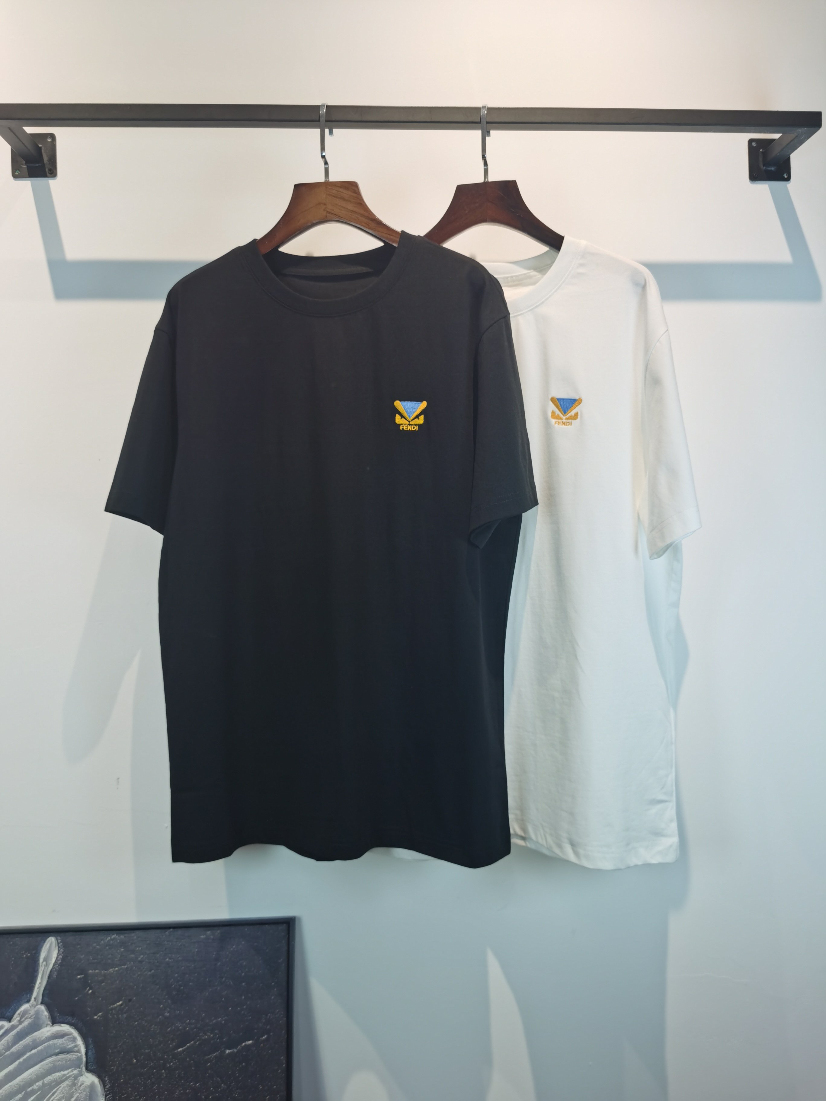 NO:847678,FENDI Fendi 2026 new embroidered short-sleeved T-shirt is on sale for pre-sale!  On sale on overseas official website!  Made of pure cotton double yarn fabric, it feels soft and delicate, the color and gloss are super positive, and the upper body is comfortable and breathable!  Customized threads on the neckline, precision double-needle patchwork, through-shoulder zipper chain bottom, durable and non-deformable, with first-class texture!  This classic round-neck T-shirt is decorated with a highly recognizable logo print on the chest. The three-dimensional and fine detail processing injects a casual charm into the whole, casual and natural, and highly recognizable!  Produced by a large factory, with fine workmanship and complete three standards!  Classic round neck basic model, the version is quite wide and full!  The upper body is fashionable, relaxed and stylish, and the atmosphere is instantly filled!  Same style for men and women!  Size S-2XL Color black white,,fendi,fendi,T-shirt,tees,t-shirt,19860909FENDI 芬迪  2026新款刺绣短袖T恤预售出货！ 海外官网在售！ 采用纯棉双纱面料,手感柔软细腻,颜色光泽度都超正,上身舒适透气！领口定织螺纹,精密双针拼缝,通肩拉锁链底耐穿不变形,质感一流！ 这款经典的圆领 T 恤胸前饰有高辨识度的logo印花,立体精细的细节处理,为整体注入一分闲适韵味,休闲自然,超高辨识度！ 大厂出品,做工精细,三标齐全！ 经典圆领基础款,版型挺阔饱满！ 上身时髦 轻松有格调 氛围感一下子拉满！ 男女同款！ 码数S-2XL 颜色黑色 白色,,fendi,fendi,T-shirt,tees，t-shirt,,Men's clothing