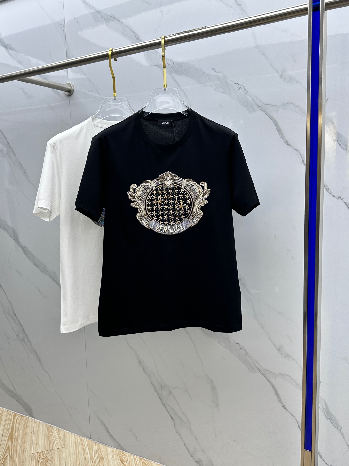 NO:118617,Versace · Versace 2025 spring and summer new men's crystal Starfish Blason T-shirt, with a shield-shaped heraldry embroidered and crystal-decorated on the front. The center of the heraldry is made of starfish and Medusa patterns, and is made of heavy craftsmanship. It is made of high-strength high-density 80 double-strand mercerized cotton fabric, the upper body is comfortable and breathable, and the fabric is delicate and slightly elastic; color black and white A20 produced code S~XXXL, versace, versace, tees, t-shirt, alexander wang19860909Versace·范思哲 2025春夏季新品男士水晶Starfish Blason T恤,正面饰有刺绣和水晶装饰的盾形纹章,纹章中央为海星和Medusa图案,重工艺打造,极具品牌辨识度的一款单品.采用高支高密80支双股丝光棉面料制成,上身舒适透气、面料细腻微弹； 颜色黑色 白色 A20出品 码数S～XXXL,,versace,versace,tees，t-shirt,alexander wang,Men's clothing