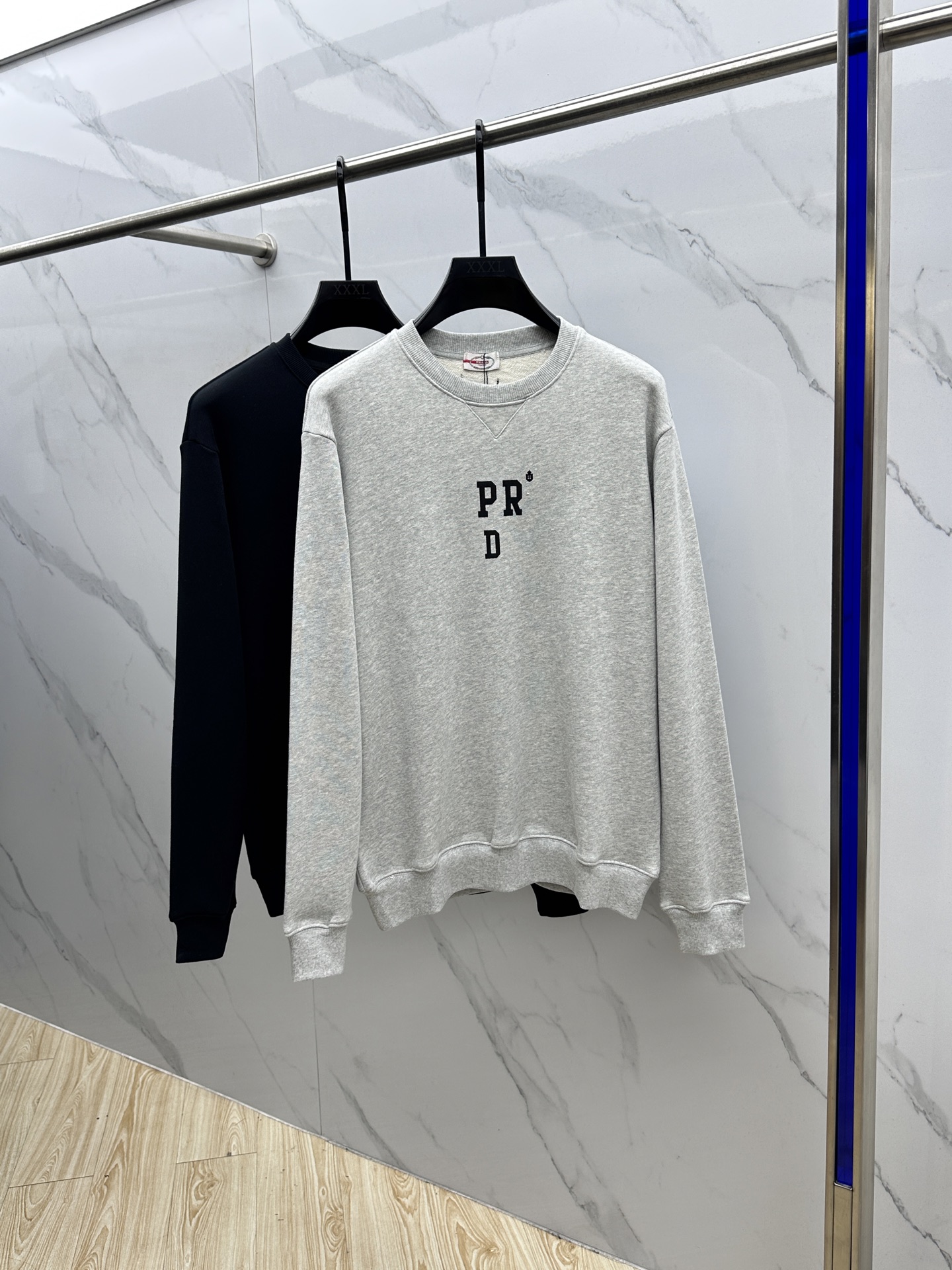 NO:523795,Prada, abbreviated as the round neck sweater. Original, purchased; cotton sweater fabric, Oversize layout design, abbreviated letter printing pattern, cuffs and bottom ribs modification, triangle logo embellishment, full set of auxiliary materials equipped # Pure cotton fish scale bottom fabric uses 36S double yarn pure cotton 7S fish scale bottom sweater fabric, 400g; matched with 21S 2×2 double yarn thread, 380g. Double yarn double yarn double yarn fabric has a high quality and delicate feel. This fabric is usually made of two yarns, thereby increasing the drooping and texture of the fabric. It has good breathability and moisture absorption, can effectively sweat, and keep the body dry and comfortable. # Simple name printing pattern  The combination of environmentally friendly thick plate printing and suede printing technology presents a unique texture and sustainable characteristic. The thick plate printing adopts the method of stacking water-based slurries multiple times to form a three-dimensional and solid relief effect, which is full of touch and resistant to water washing; the suede printing uses the addition of fluff materials to the slurry and foams at high temperature to form a soft and delicate suede texture. It not only highlights the three-dimensional layer of the pattern, but also gives the fabric a soft touch. # Fabric triangle fabric retro effect The characteristics of the classic brand triangle weaving mark on the front are made of the same body fabric through infrared cutting technology. The triangular fabrics are superimposed and matched in different sizes, and the seams are fixed to embellish the chest. The inverted triangle logo breaks the conventional design, retro, simple and unique. # Classic round neck basic pattern design  Loose round neck pullover sweatshirt, the back collar is not easy to deform. The collar ring, shoulder seam, rear piece, hem and sleeve cage adopt double-needle thread cross-seaming process, and the bone seam is not prone to explosive thread to improve the firmness; the neckline, cuff and hem are threaded in the same cylinder. Hei Size M-3XL,,prada,versace,hoodie,sweatshirts,alexander wang19860909Prada、简称字母圆领卫衣 原,购买；棉质卫衣面料、Oversize 版型设计、简称字母印花图案、袖口及底边罗纹修饰、三角徽标点缀、全套辅料配备 # 纯棉质鱼鳞底面料 采用36S双纱纯棉质面7S鱼鳞底卫衣面料,400g；搭配21S 2×2 双纱螺纹,380g.双纱双面卫衣面料具有较高的品质和细腻的手感.这种面料通常是由两根纱线绕制而成,从而增加了面料的垂感和质感.具有较好的透气性和吸湿性,能够有效地排汗,保持身体干爽舒适. # 简字名称印花图案 环保厚板印花与绒面印花工艺结合,呈现出独特质感与可持续特性.厚板印花采用多次堆叠水性浆料的方式,形成立体坚固的浮雕效果,触感饱满且耐水洗；绒面印花则通过在浆料中添加绒毛材料,经高温发泡形成柔软细腻的绒面质感.既能突出图案的立体层次,又赋予织物柔软触感. # 织物三角布复古效果 正面经典品牌三角形织标的特点,采用同身面料通过红外线切割技术.不同尺寸三角布叠加搭配,车缝固定点缀胸前.倒三角标志打破了常规设计,复古简约又富有个性. # 经典圆领基础版型设计 宽松圆领套头卫衣,后领人织带包领不易变形.领圈、肩缝、后片、下摆、袖笼采用双针车线跨缝工艺,骨缝不易爆线提高牢固功能；领口、袖口和下摆同缸螺纹收口.hei 尺码M-3XL,,prada,versace,hoodie,sweatshirts,alexander wang,Men's clothing