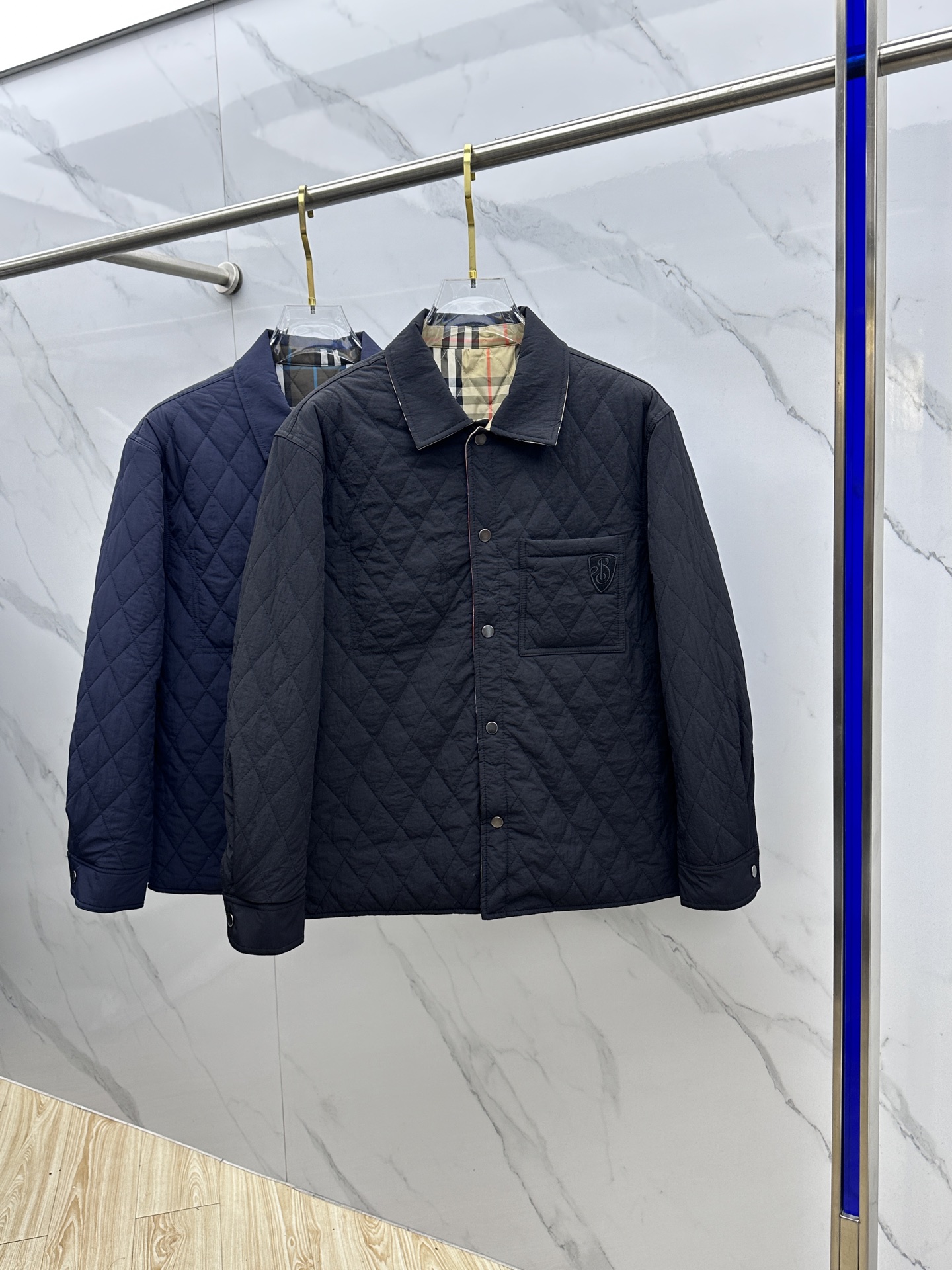 NO:690742,2025 Autumn and Winter New Style~BBR Reversible Quilted Cotton Jacket This reversible quilted jacket embodies the British philosophy of luxury and warmth that can be worn in two ways!  One side is a solid-color nylon design, with a simple and elegant quilted diamond grid, which is low-key and exquisite; the other side is the iconic Burberry plaid cotton twill fabric, where the classic plaid collides with blue lines, instantly awakening the memory of British fashion. The double-sided look is not only a cool minimalist texture, but also a retro carnival for plaid fans.  The casual fit is compatible with various styles, and the hardware buttons and exquisite embroidered logo details add a sense of quality; the padding inside brings just the right amount of warmth, allowing you to travel calmly between the streets and the workplace in the cooler weather.se Sizes M-3XL,,burberry,jackets & coats,198609092025秋冬新款~BBR双面穿绗缝棉服外套 这款双面穿绗缝外套一衣两穿的英伦奢暖哲学！ 一面是纯色尼龙设计,简约大气的绗缝菱形格,低调中透着精致；另一面则是标志性Burberry格纹棉质斜纹面料,经典格纹与蓝调线条碰撞,瞬间唤醒英伦时尚记忆.双面穿搭,既是极简主义的清冷质感,也是格纹拥趸的复古狂欢. 休闲版型兼容各种风格,五金纽扣与精致刺绣徽标细节拉满品质感；内里填充带来恰到好处的暖意,让你在微凉时节从容穿梭于街头与职场.se 尺码M-3XL,,burberry,jackets & coats,,Men's clothing