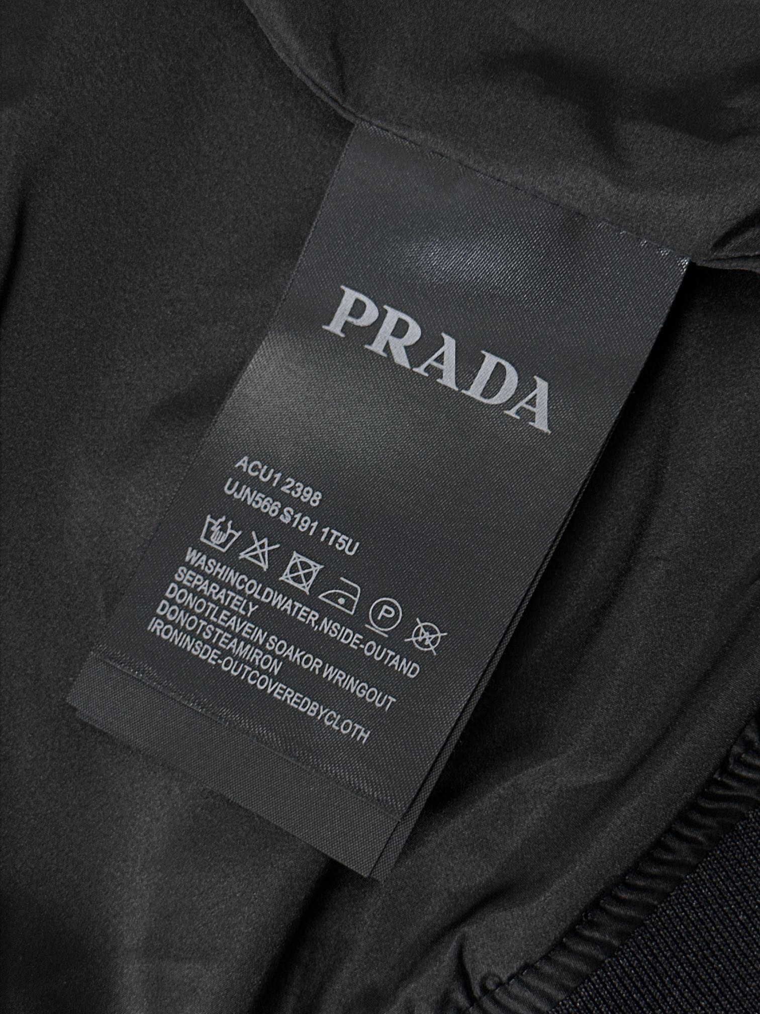 P320  891 PRA……普拉达 春秋季立领夹克！先上先卖，抢占先机。PRADA/普拉达 新品立领风衣外套。这款轻质尼龙夹克配有可拆卸帽和正面拉链，下摆特殊设计，颇具休闲装设计特色。胸前拼接口袋饰有标志性的三角形珐琅徽标，演绎品牌风范。正面拉链式口袋，饰有涂珐琅三角形金属徽标，正面拉链拉合，聚酰胺纤维面料。宝蓝 黑色 尺码：48-56