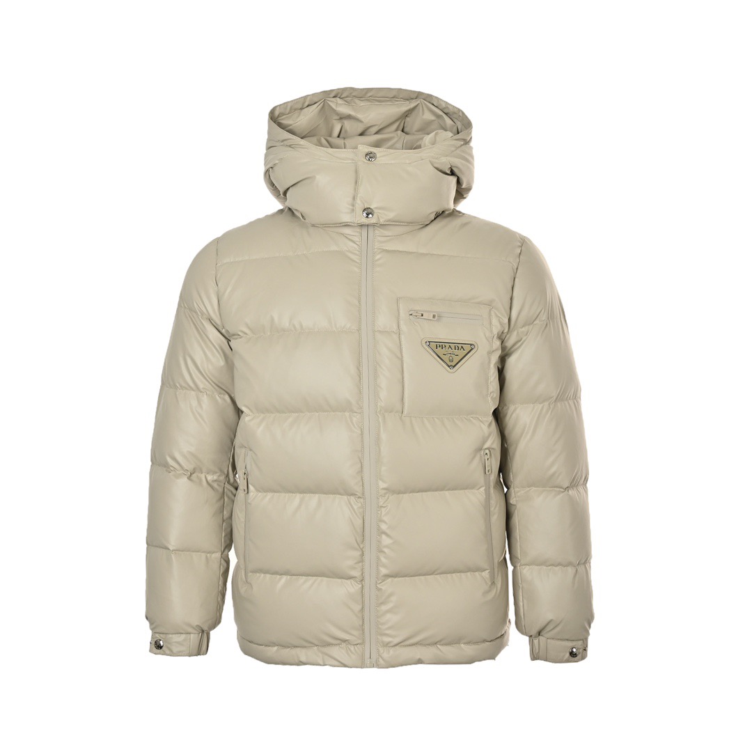 本地自取: Prada/普拉达 24Fw 拉链口袋三角标羽绒服 此款廓形丰满的羽绒外套采用Linea rossa独特的双层轻质粘合尼龙面料打造,搭配连帽衣领、直裁衣袖和正面拉链拉合,与横向绗缝,元素和下摆弹力束绳共同塑造鲜明廓形,轻质粘合尼龙科技面料具有防风、耐磨、防水和透气等,高科技性能,是一款多功能科技面料,衬里采用精细密实的可再生微纤维面料打造,触感轻盈,柔软,鹅绒和 Graphene加衬有助于调节体温,别具功能性,鸭绒材质赋予加衬填料更加轻盈的特色,提升服装的保温性能