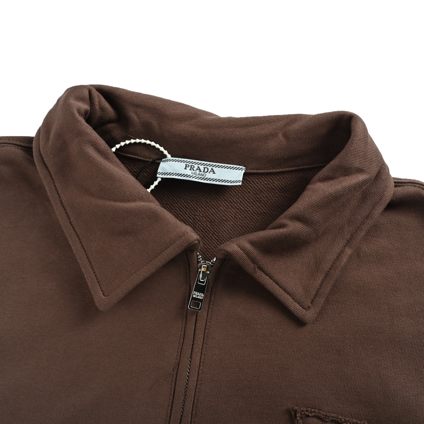 本地自取：💰220
Prada/普拉达 25Fw 三角布标半拉链翻领卫衣
· 采用480克纯棉双纱鱼鳞毛圈面料  
· 面部无尘烧毛工艺 底部吸毛 环保活性染 
· 胸口手工裁剪三角形贴布刺绣
· 半开拉链设计，定制五金拉链
· 侧边拼接螺纹
· 双针车线跨缝工艺
· 原版主唛水洗吊牌防潮纸包装
   颜色：棕色
   Size:S-XL