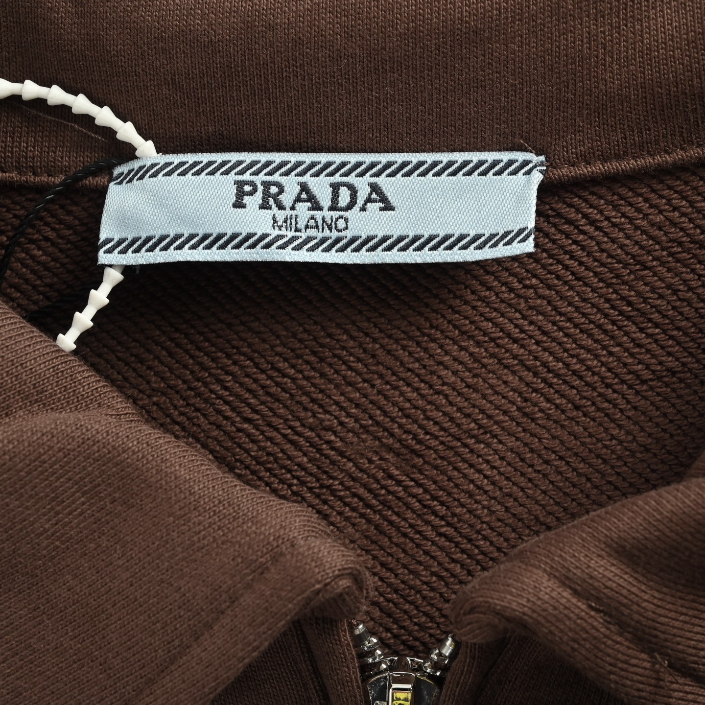 本地自取：💰220
Prada/普拉达 25Fw 三角布标半拉链翻领卫衣
· 采用480克纯棉双纱鱼鳞毛圈面料  
· 面部无尘烧毛工艺 底部吸毛 环保活性染 
· 胸口手工裁剪三角形贴布刺绣
· 半开拉链设计，定制五金拉链
· 侧边拼接螺纹
· 双针车线跨缝工艺
· 原版主唛水洗吊牌防潮纸包装
   颜色：棕色
   Size:S-XL