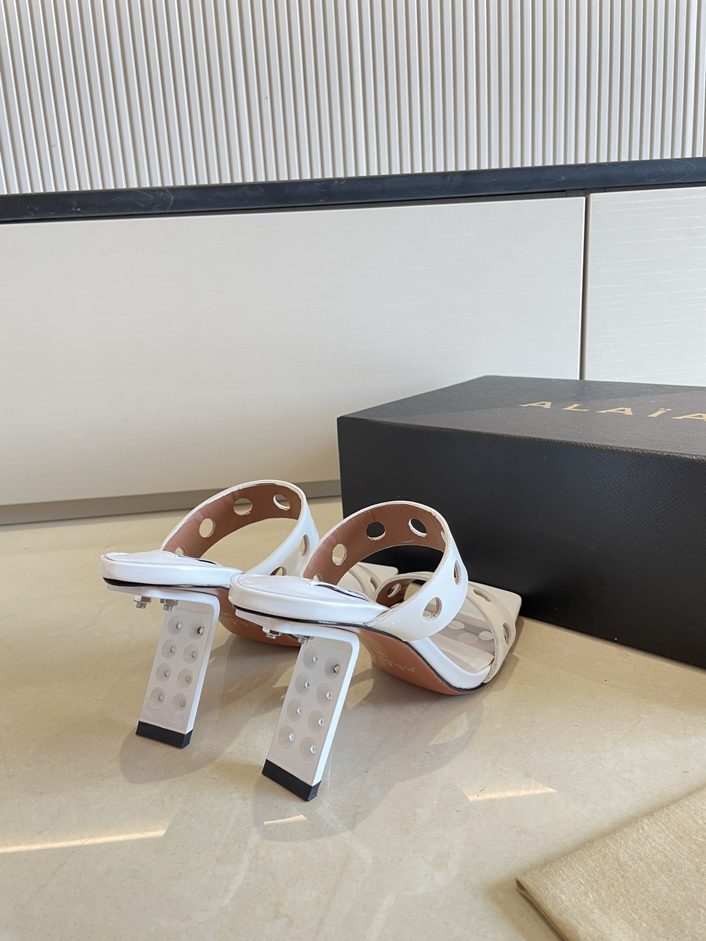 
钢琴烤漆 几何跟 Alaia 镂空拖鞋来自巴黎 一见倾心 
白色小牛漆皮 
精钢几何跟型 

阿莱娅还