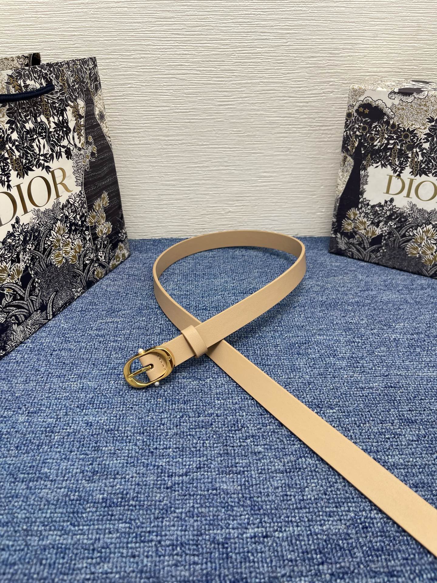 NO:140250,Original Dior Chic Belt 20mm Beige Smooth Cowhide Leather Number: B0667UBGO_M900. This Dior Chic Belt is a new product in the spring and summer 2025 ready-to-wear series, highlighting the classic elegance. It is carefully crafted from black smooth cowhide leather and other materials, decorated with a glossy gold finish metal belt buckle to highlight elegant lines, engraved with CD logo and embellished with two white resin beads. Classic elegance, cleverly highlighting the waist curve, and can be matched with jeans, skirts or dresses. Dior Chic Belt buckle engraved with CD logo White resin beads Inside with Christian Dior Paris logo glossy gold finish metal details Cowhide Leather, brass, aluminum Made in Italy  Due to technical limitations, product improvement or production batches, the information on the website may have color difference, size error or other detailed errors. The product pictures displayed on the website may be inconsistent with the actual appearance of the product, and the actual product shall prevail. If you have any related questions, please call Dior Customer Service Center., belts, dior, dior, skirts, jeans, cowhide19860909原单 Dior Chic 腰带 20 毫米米色光滑牛皮革 编号: B0667UBGO_M900. 这款 Dior Chic 腰带是二零二五春夏成衣系列新品,彰显优雅经典.采用黑色光滑牛皮革等材质精心制作,饰以富有光泽的金色饰面金属腰带扣,彰显优雅线条,并镌刻以 CD 标志,点缀以两颗白色树脂珠饰.经典优雅,巧妙突显腰部曲线,可与牛仔裤、半身裙或连衣裙搭配. 镌刻有 CD 标志的 Dior Chic 腰带扣 白色树脂珠饰 内侧饰以 Christian Dior Paris 标志 富有光泽的金色饰面金属细节 牛皮革,黄铜,铝 意大利制造 因技术局限、产品改良或生产批次等原因,网站中的信息可能存在色差、尺码误差或其他细节误差,网站展示的产品图片可能与产品实际外观不一致,以产品实物为准.如有相关问题,请致电迪奥客服中心.,皮带,dior,dior,skirts,jeans,cowhide,Belt