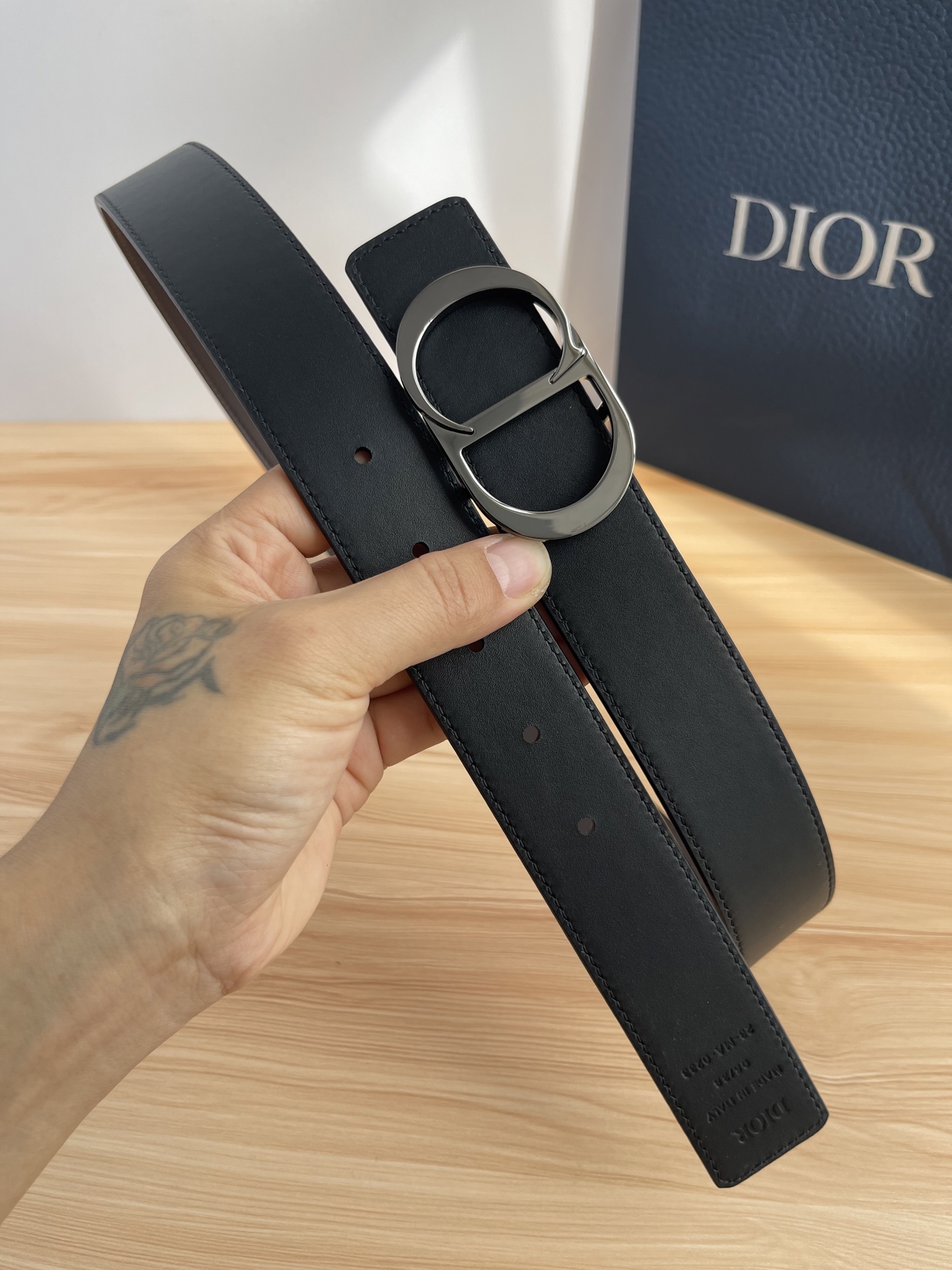 P 这款 35 毫米双面腰带结合典雅气质与摩登风范。 配一面采用黑色 Dior Gravity 印花效果