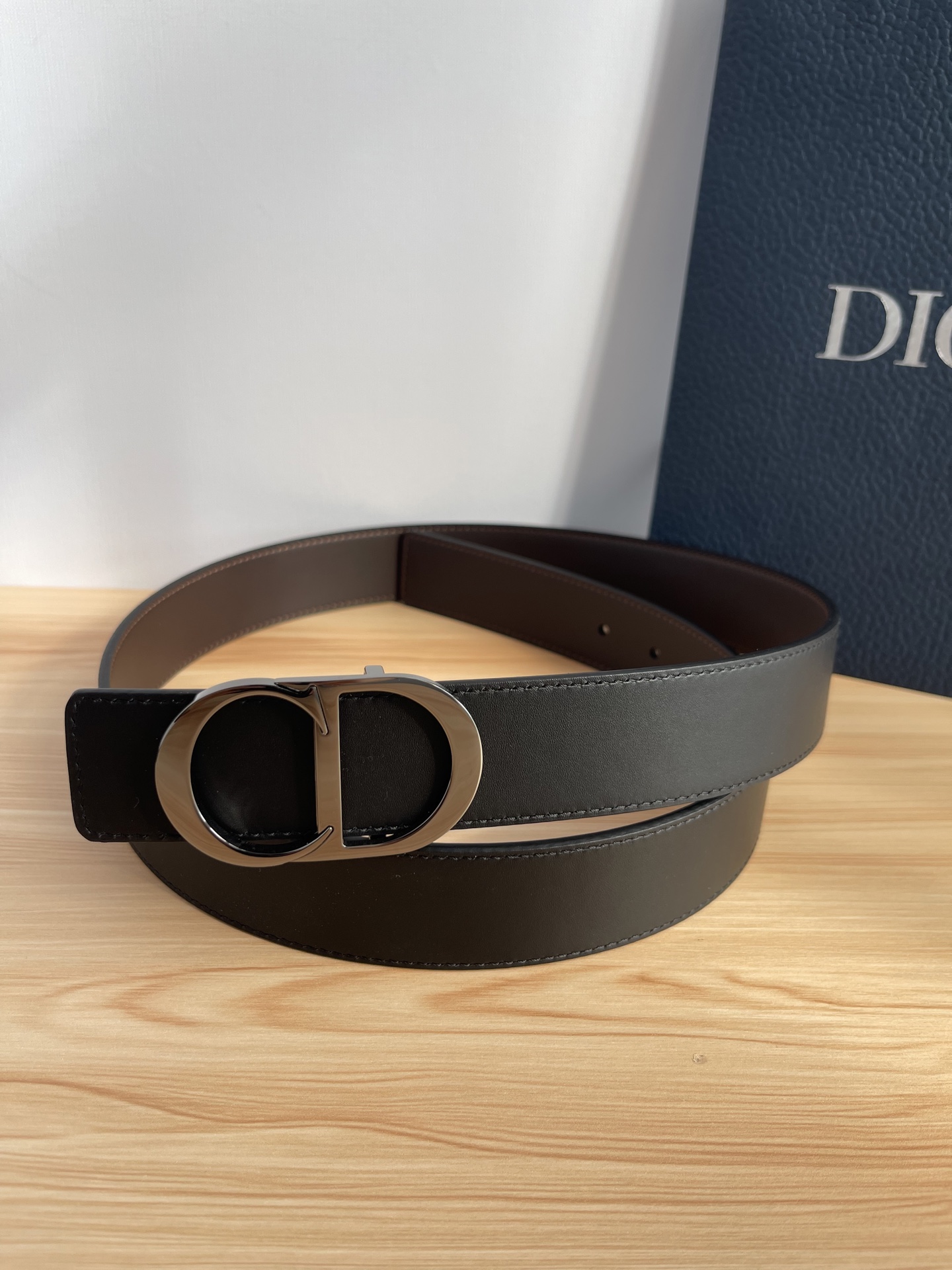 P 这款 35 毫米双面腰带结合典雅气质与摩登风范。 配一面采用黑色 Dior Gravity 印花效果