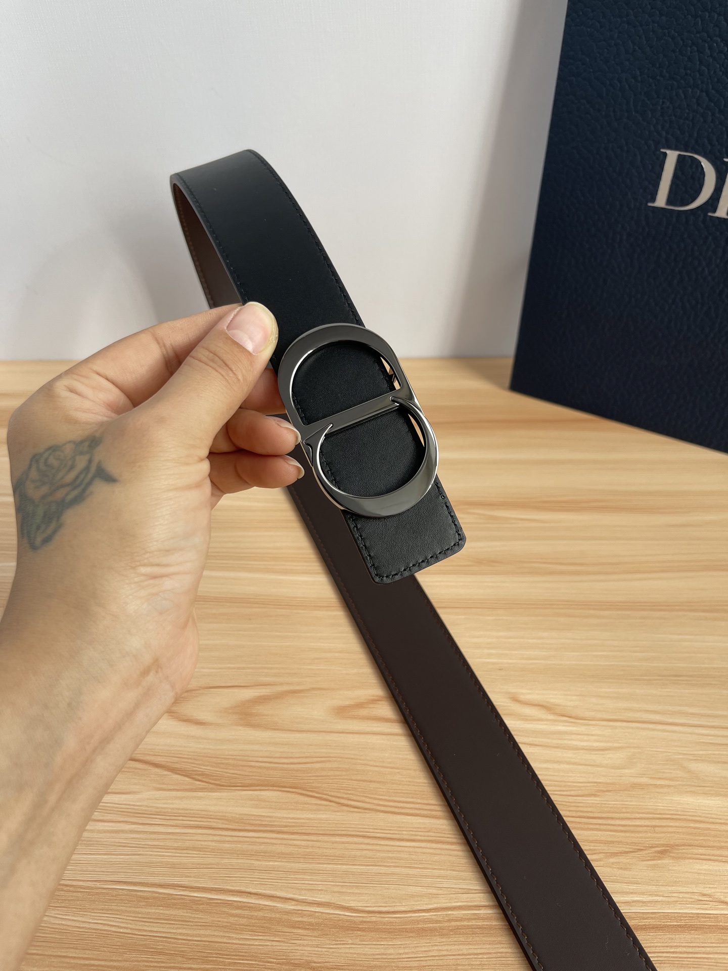 P 这款 35 毫米双面腰带结合典雅气质与摩登风范。 配一面采用黑色 Dior Gravity 印花效果