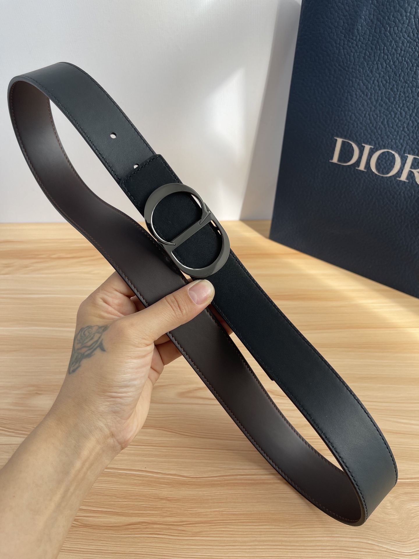 P 这款 35 毫米双面腰带结合典雅气质与摩登风范。 配一面采用黑色 Dior Gravity 印花效果
