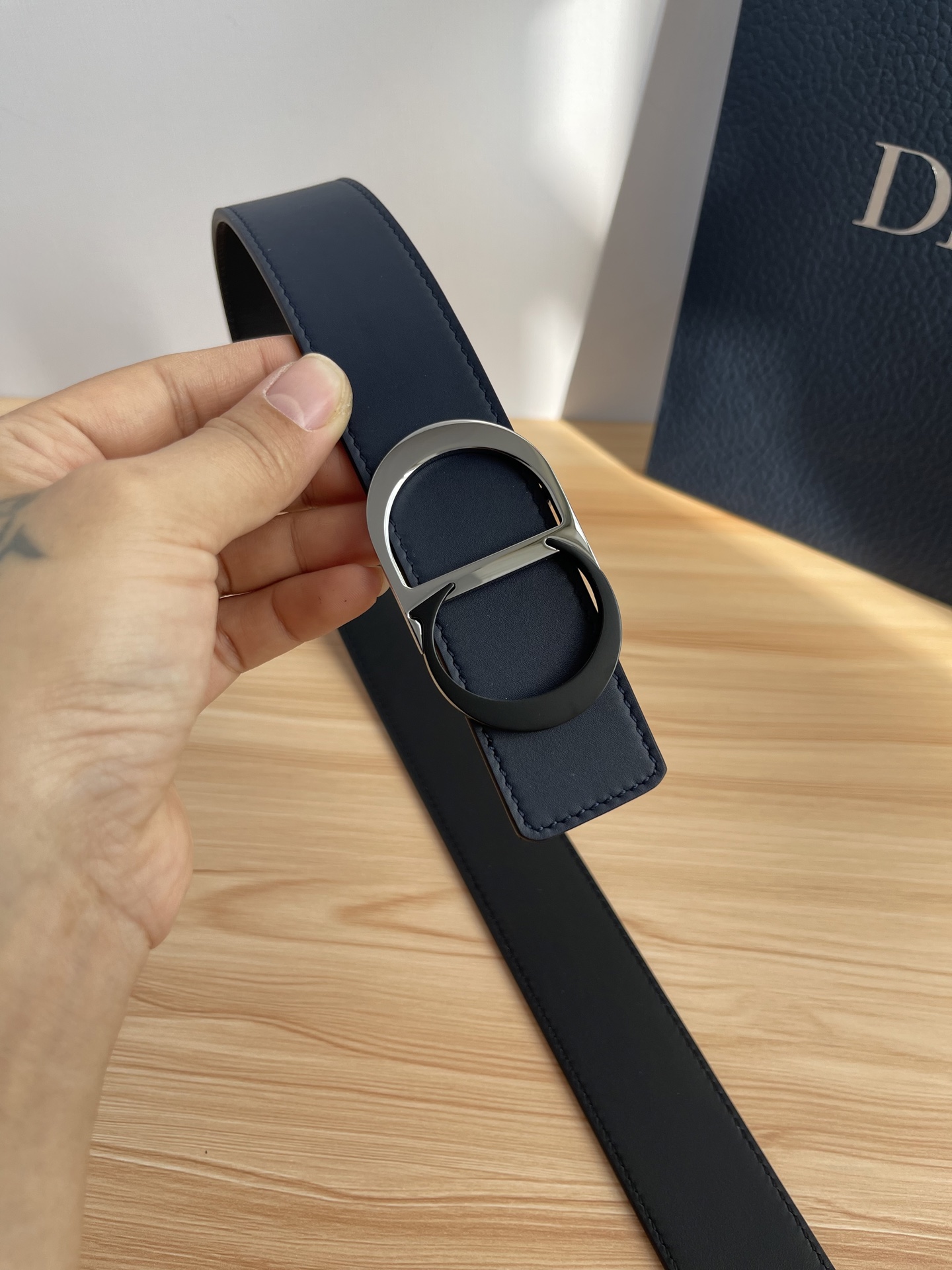 P 这款 35 毫米双面腰带结合典雅气质与摩登风范。 配一面采用黑色 Dior Gravity 印花效果