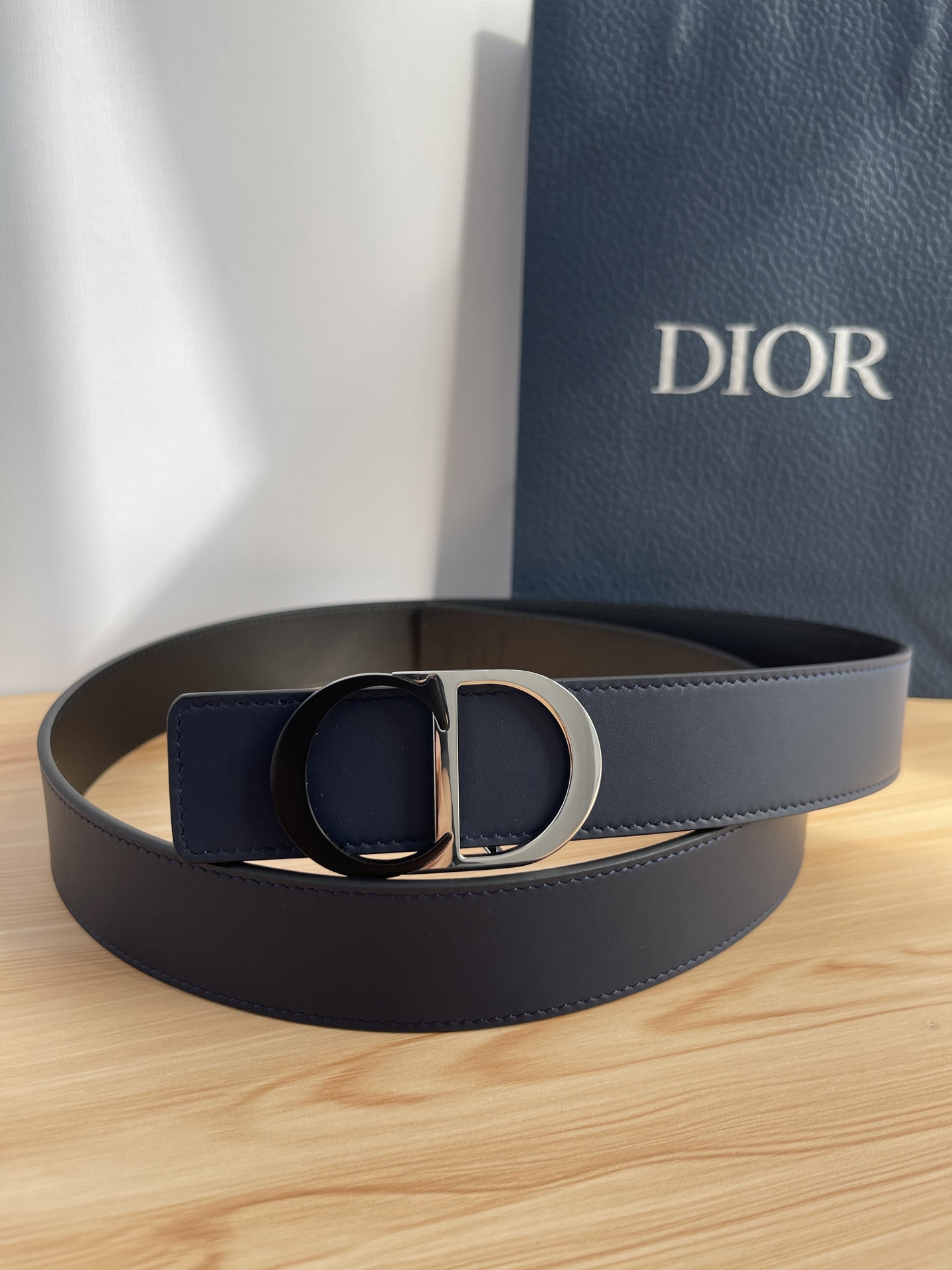 P 这款 35 毫米双面腰带结合典雅气质与摩登风范。 配一面采用黑色 Dior Gravity 印花效果