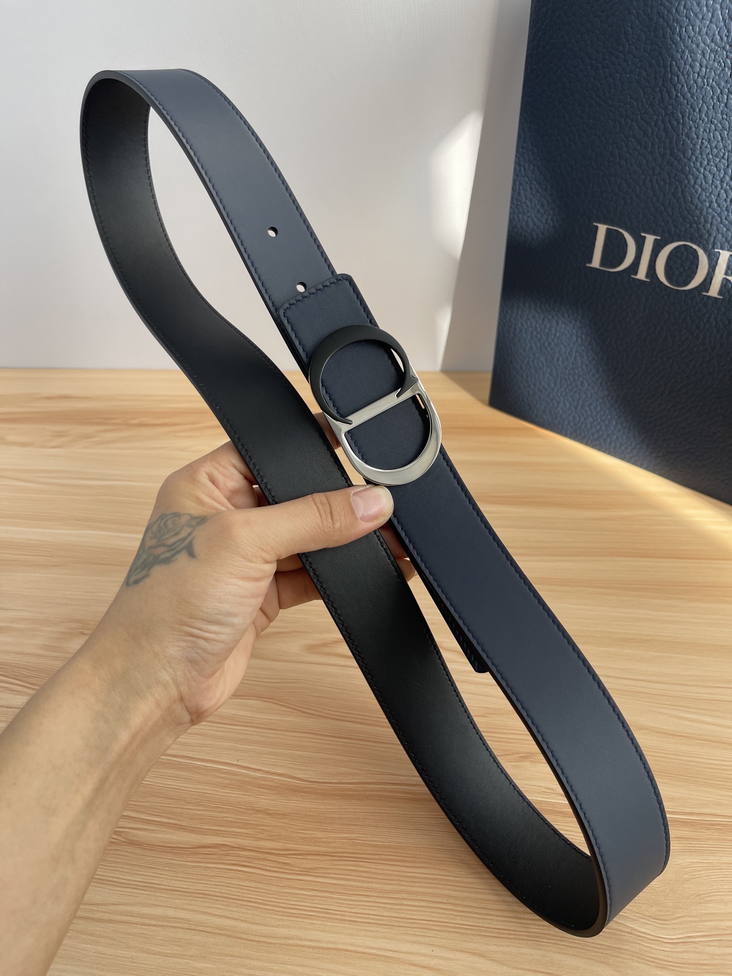 P 这款 35 毫米双面腰带结合典雅气质与摩登风范。 配一面采用黑色 Dior Gravity 印花效果