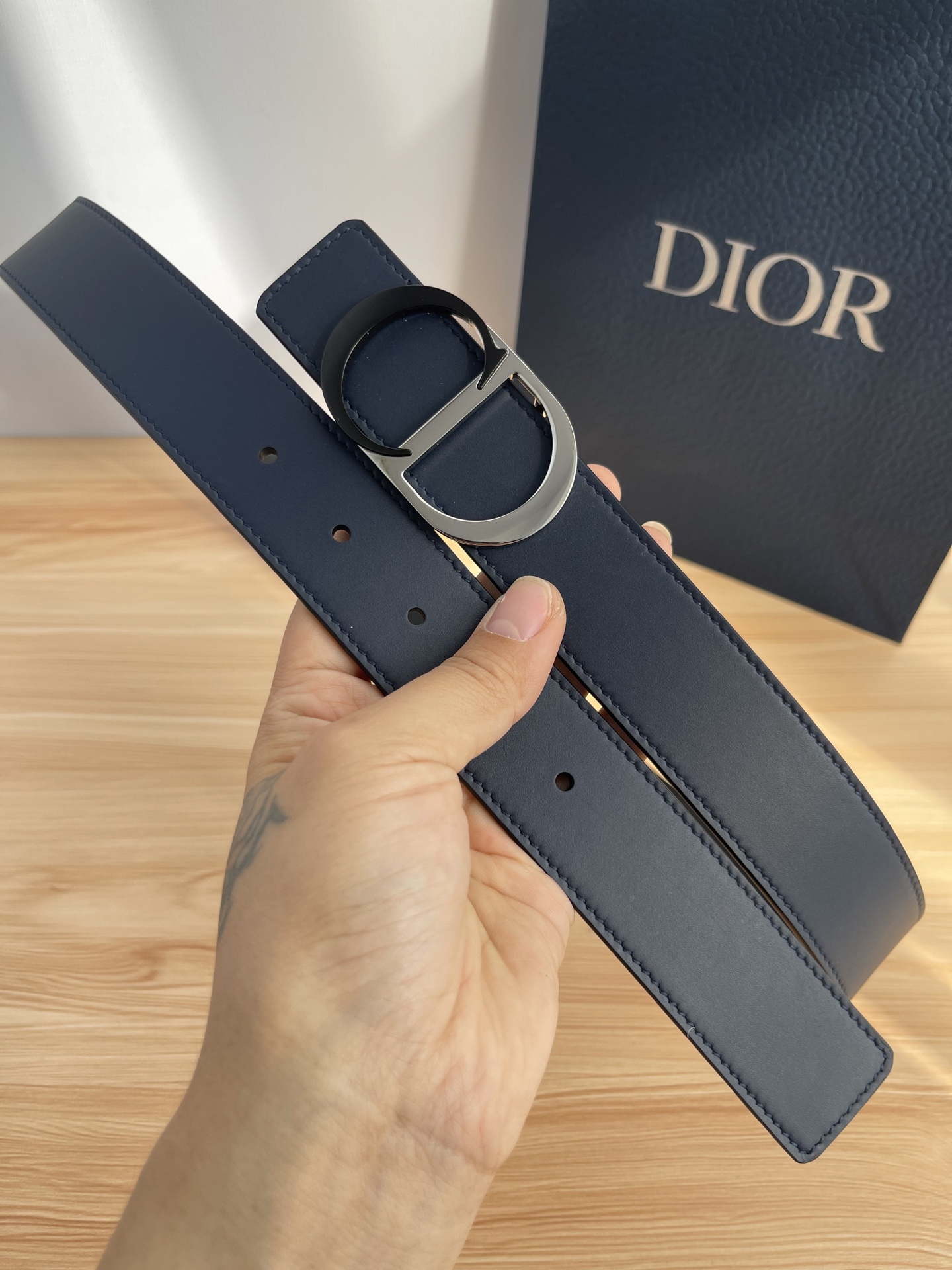 P 这款 35 毫米双面腰带结合典雅气质与摩登风范。 配一面采用黑色 Dior Gravity 印花效果