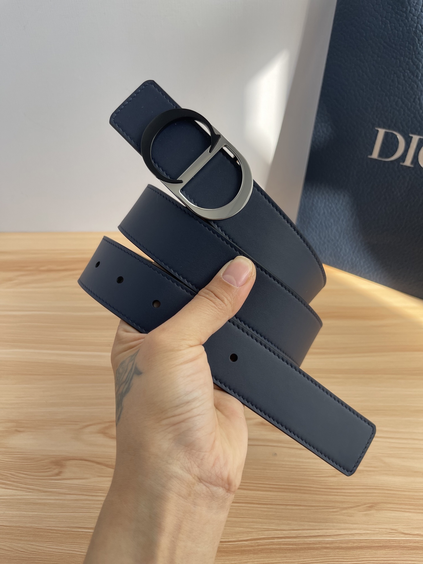 P 这款 35 毫米双面腰带结合典雅气质与摩登风范。 配一面采用黑色 Dior Gravity 印花效果