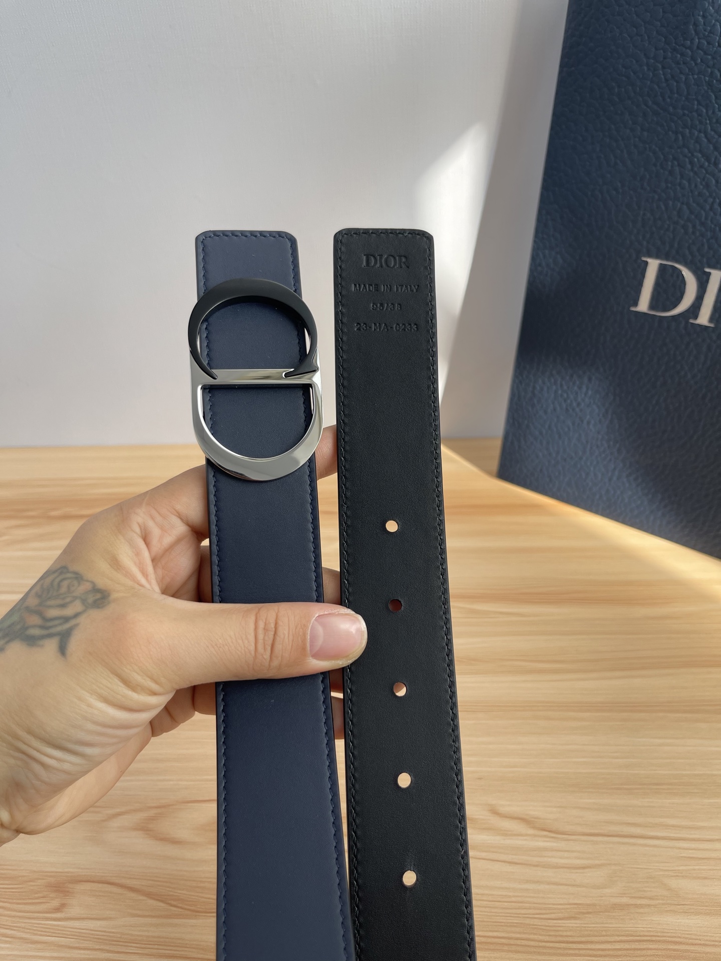 P 这款 35 毫米双面腰带结合典雅气质与摩登风范。 配一面采用黑色 Dior Gravity 印花效果