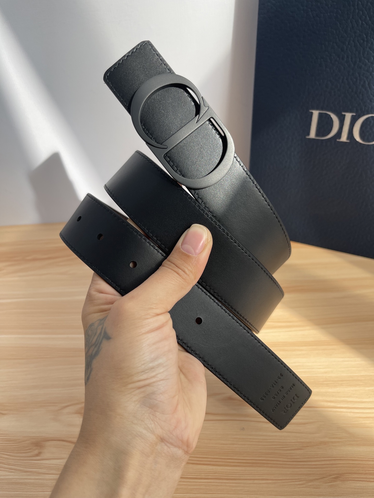 P 这款 35 毫米双面腰带结合典雅气质与摩登风范。 配一面采用黑色 Dior Gravity 印花效果