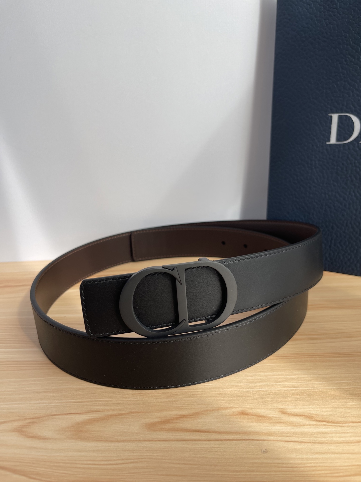 P 这款 35 毫米双面腰带结合典雅气质与摩登风范。 配一面采用黑色 Dior Gravity 印花效果