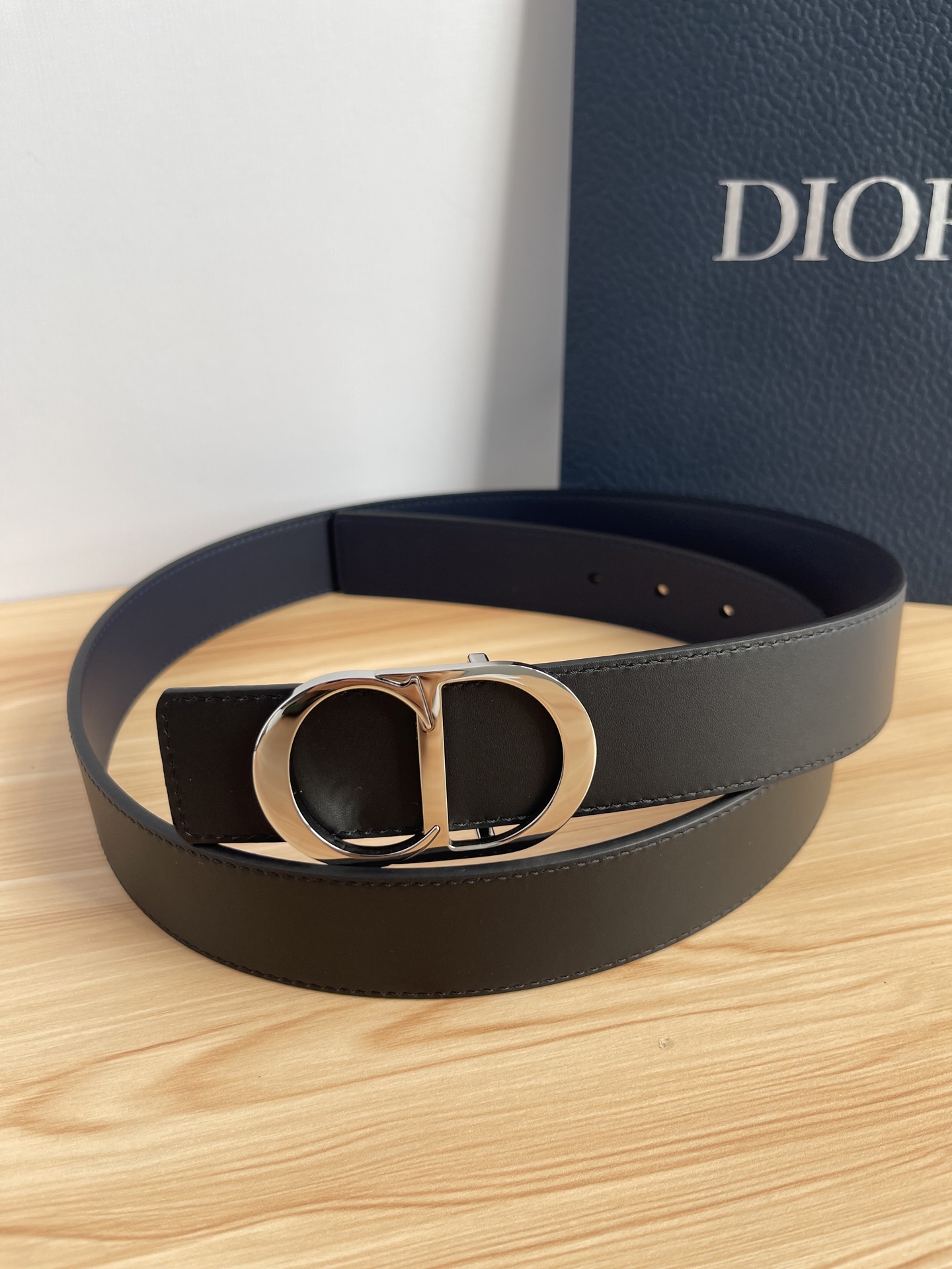 P 这款 35 毫米双面腰带结合典雅气质与摩登风范。 配一面采用黑色 Dior Gravity 印花效果