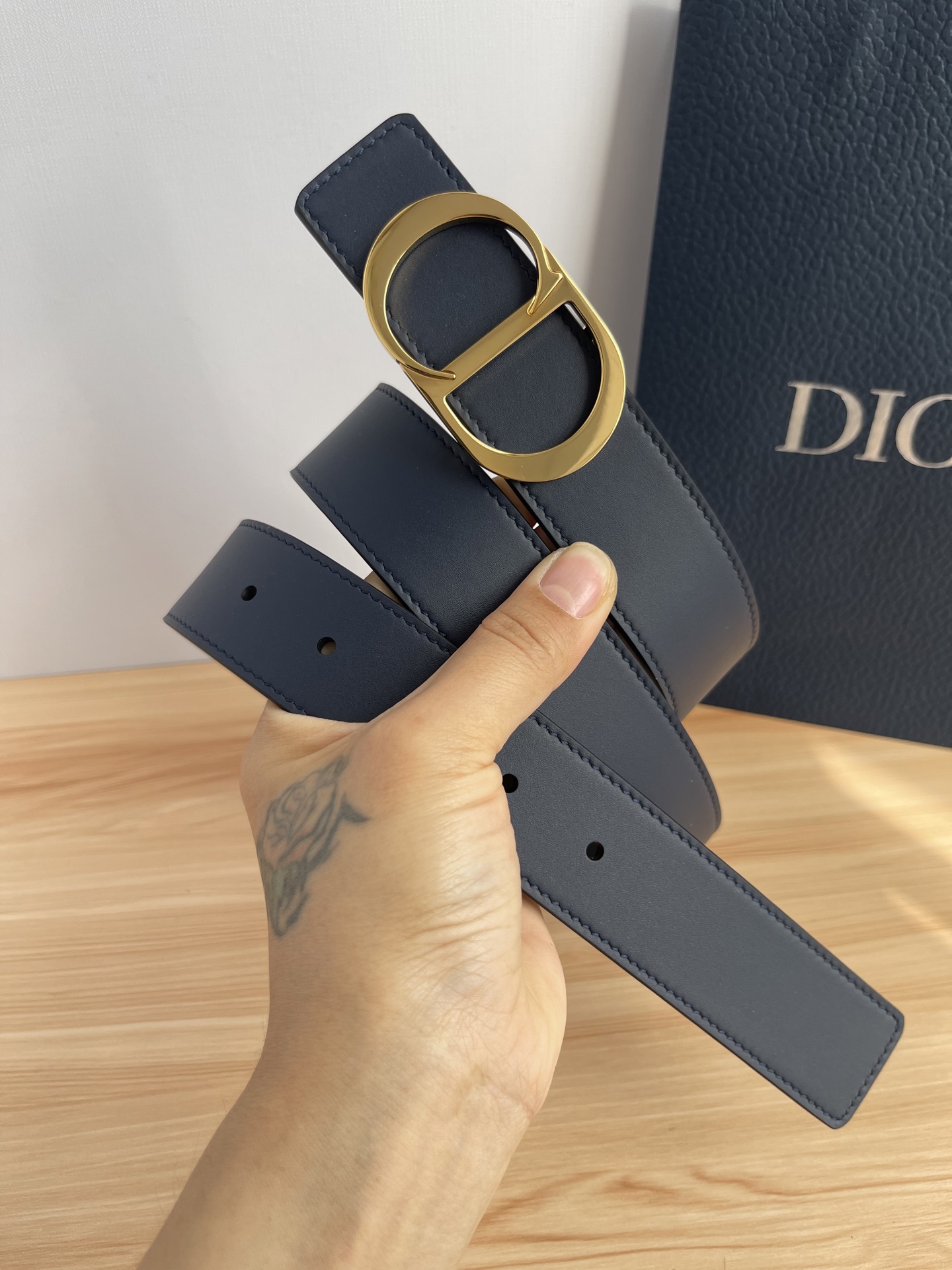 P 这款 35 毫米双面腰带结合典雅气质与摩登风范。 配一面采用黑色 Dior Gravity 印花效果