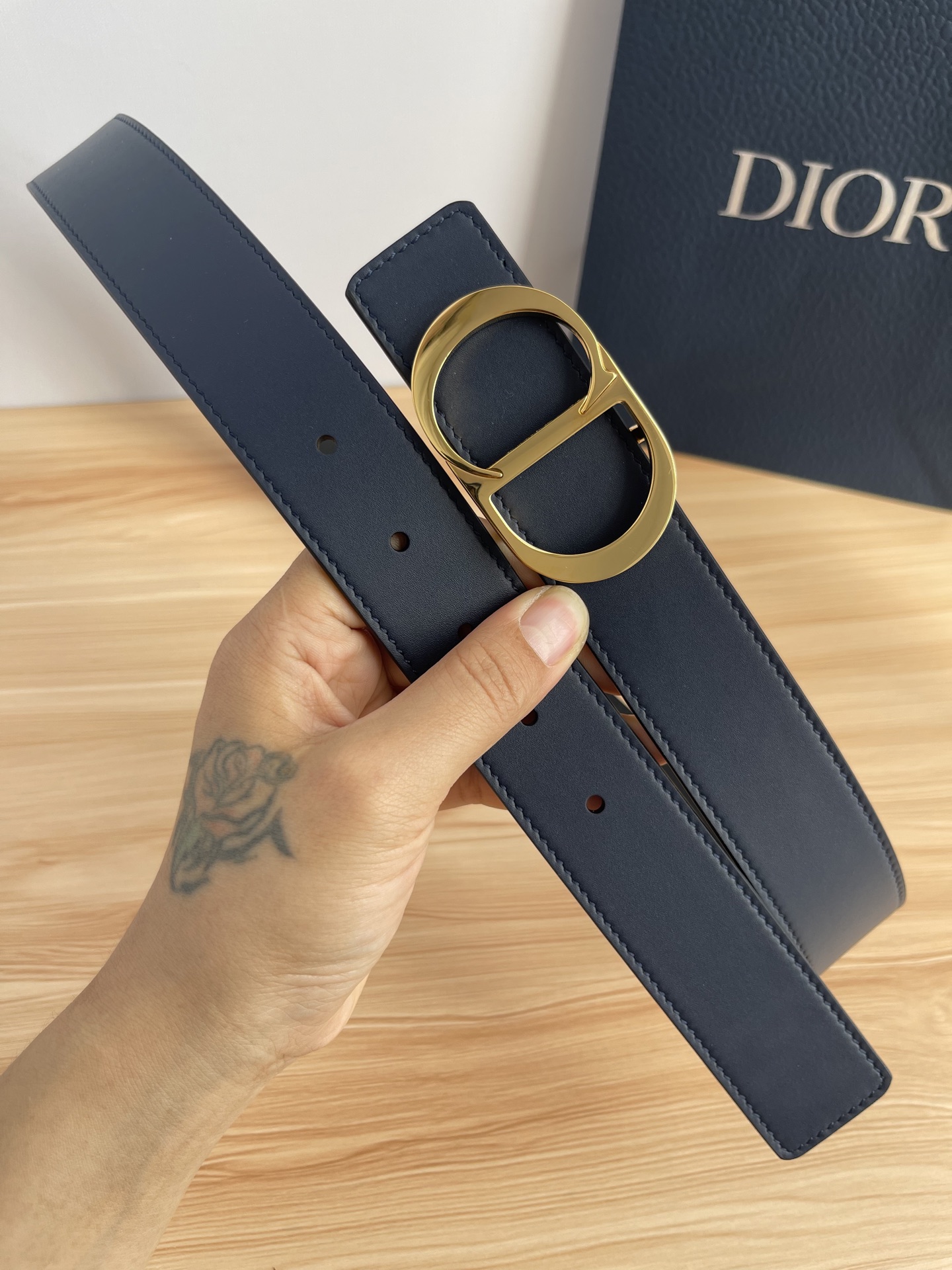 P 这款 35 毫米双面腰带结合典雅气质与摩登风范。 配一面采用黑色 Dior Gravity 印花效果