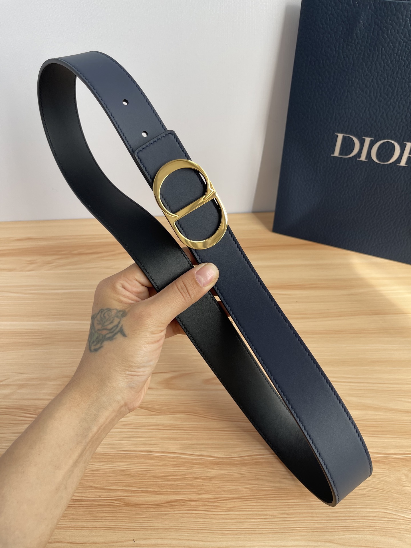 P 这款 35 毫米双面腰带结合典雅气质与摩登风范。 配一面采用黑色 Dior Gravity 印花效果