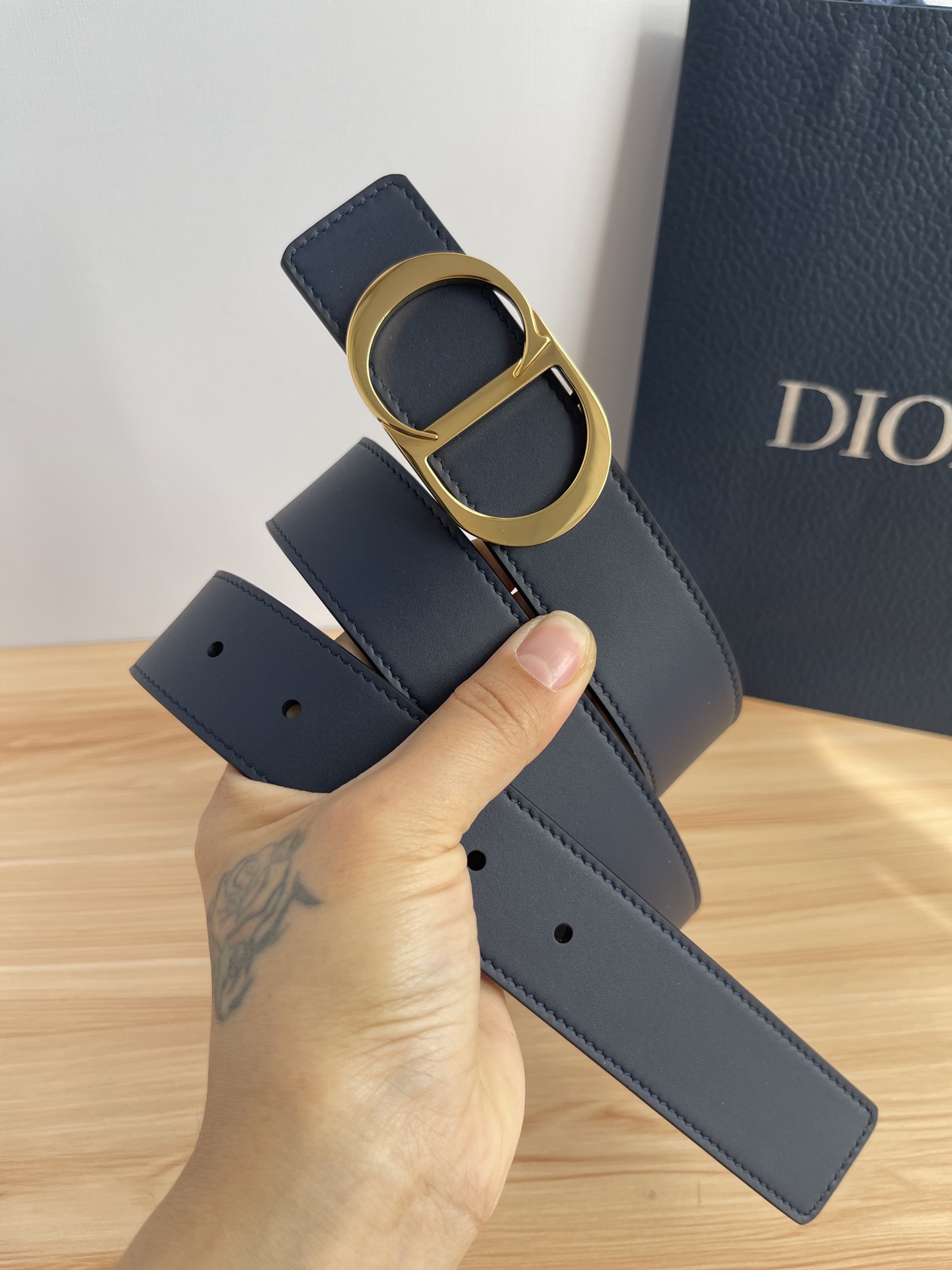 P 这款 35 毫米双面腰带结合典雅气质与摩登风范。 配一面采用黑色 Dior Gravity 印花效果