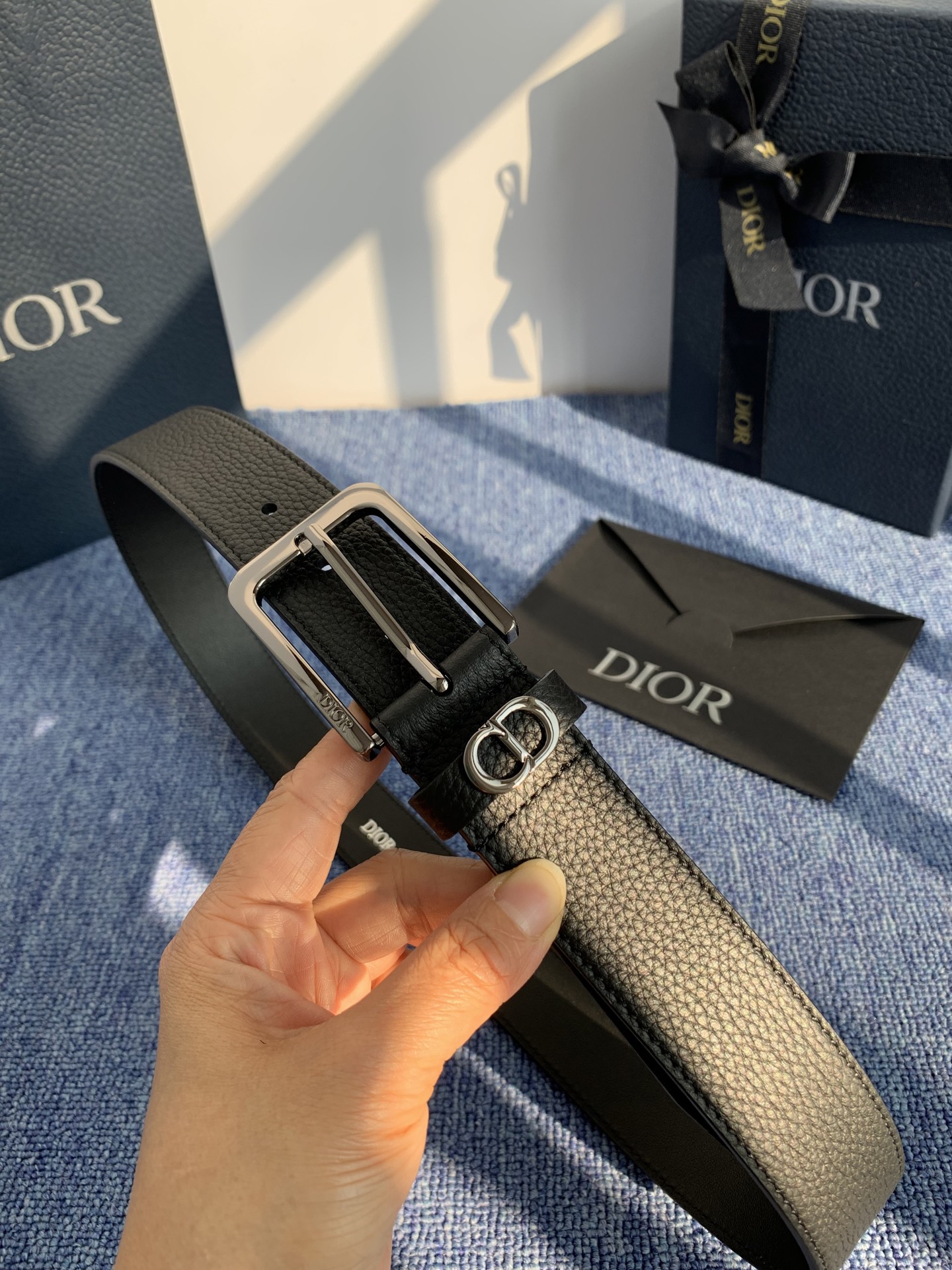 采用黑色粒面牛皮革精心制作，饰以镌刻有 Dior 的针扣和黑色金属覆层铜合金 CD Icon 标志腰带环