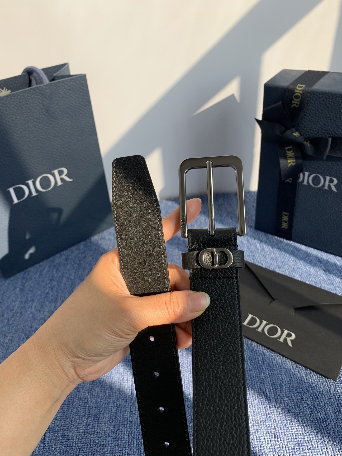 采用黑色粒面牛皮革精心制作，饰以镌刻有 Dior 的针扣和黑色金属覆层铜合金 CD Icon 标志腰带环