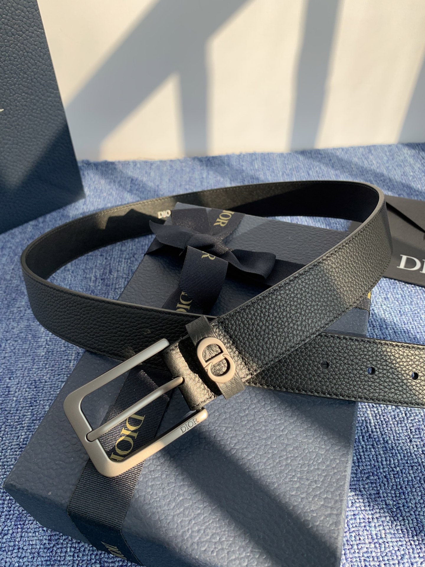 采用黑色粒面牛皮革精心制作，饰以镌刻有 Dior 的针扣和黑色金属覆层铜合金 CD Icon 标志腰带环