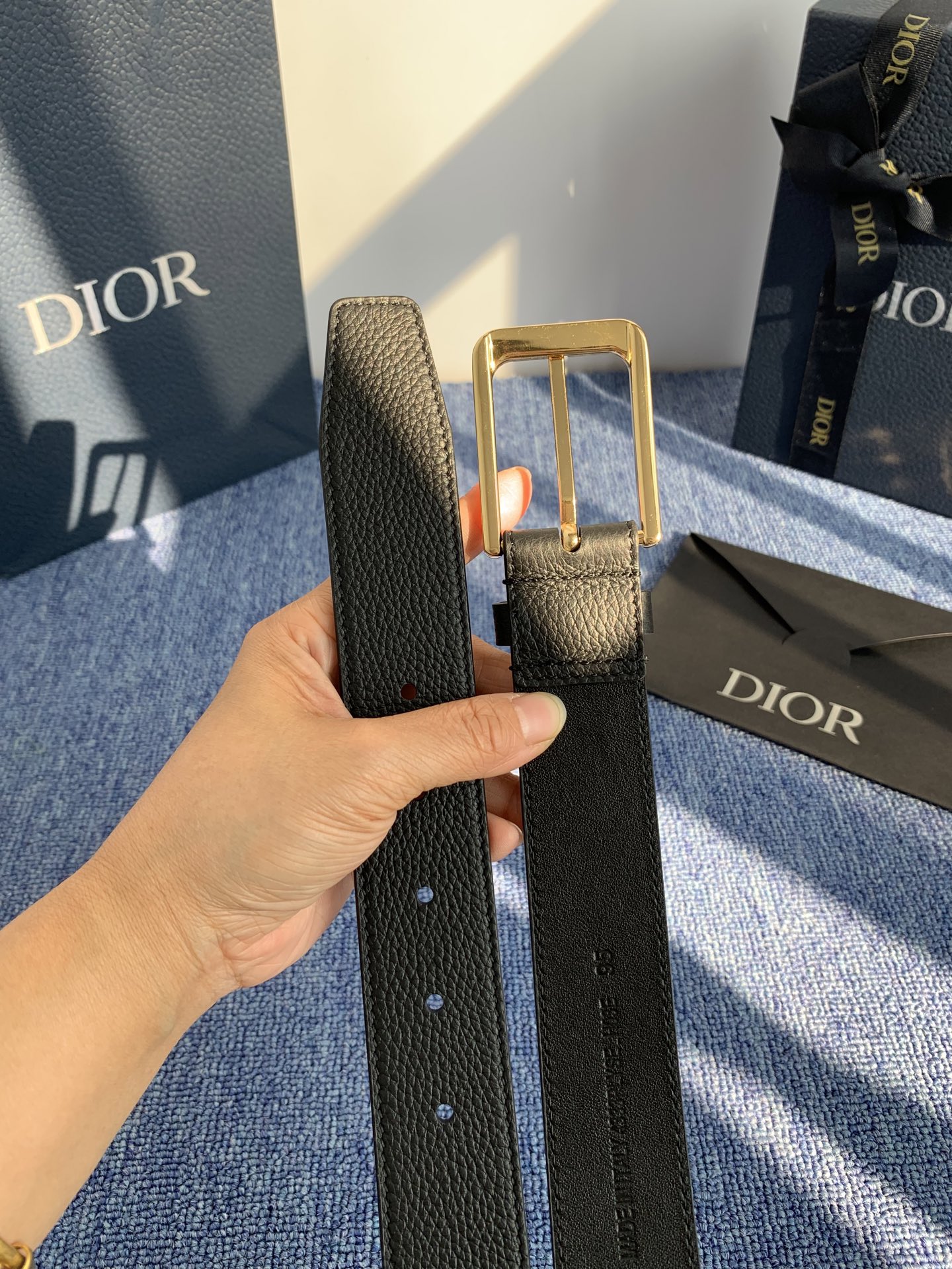 采用黑色粒面牛皮革精心制作，饰以镌刻有 Dior 的针扣和黑色金属覆层铜合金 CD Icon 标志腰带环