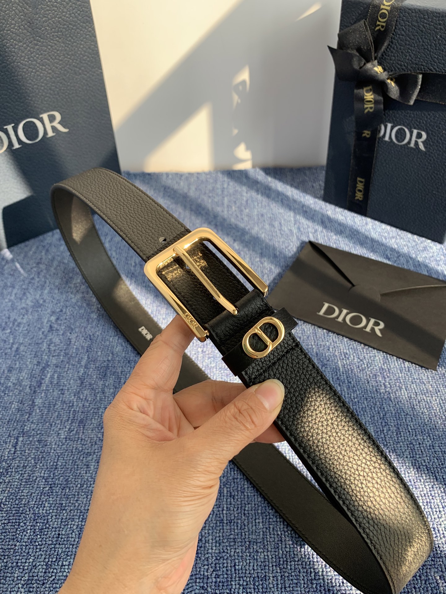 采用黑色粒面牛皮革精心制作，饰以镌刻有 Dior 的针扣和黑色金属覆层铜合金 CD Icon 标志腰带环
