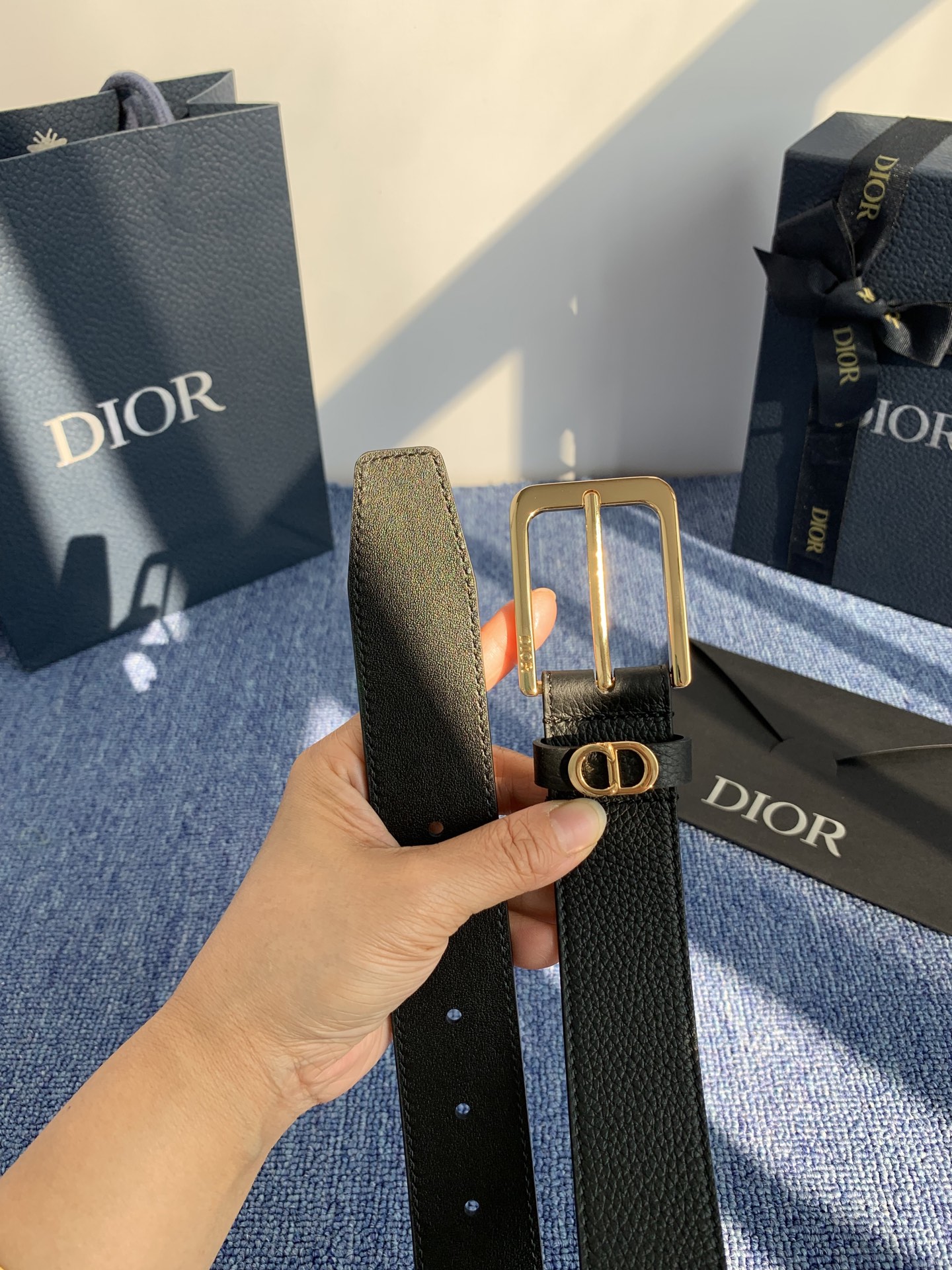 采用黑色粒面牛皮革精心制作，饰以镌刻有 Dior 的针扣和黑色金属覆层铜合金 CD Icon 标志腰带环