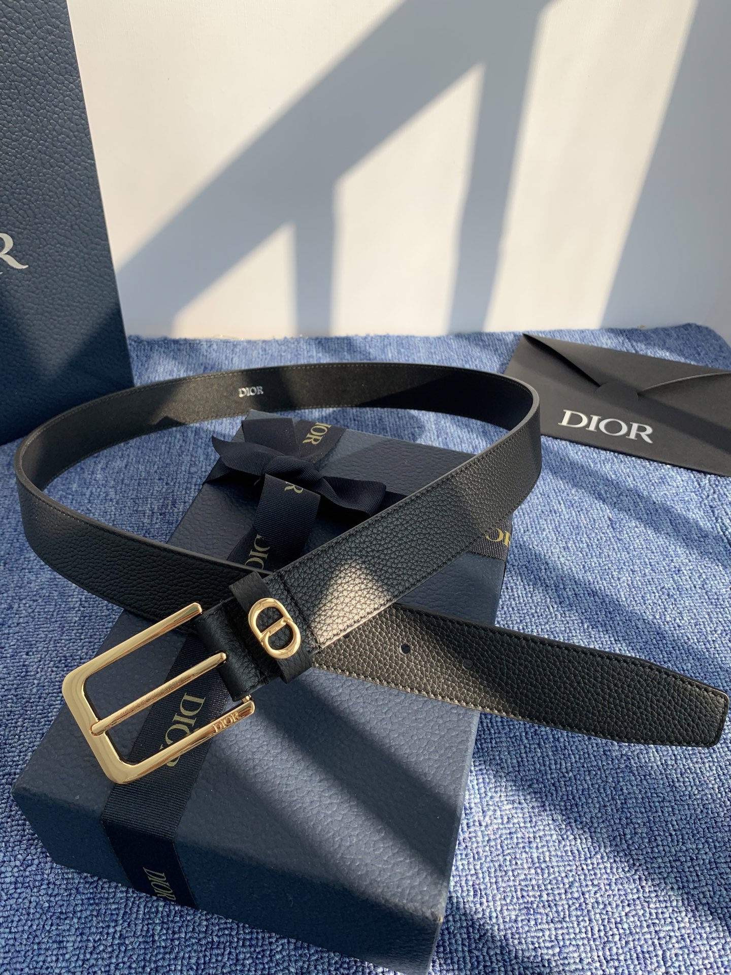 采用黑色粒面牛皮革精心制作，饰以镌刻有 Dior 的针扣和黑色金属覆层铜合金 CD Icon 标志腰带环