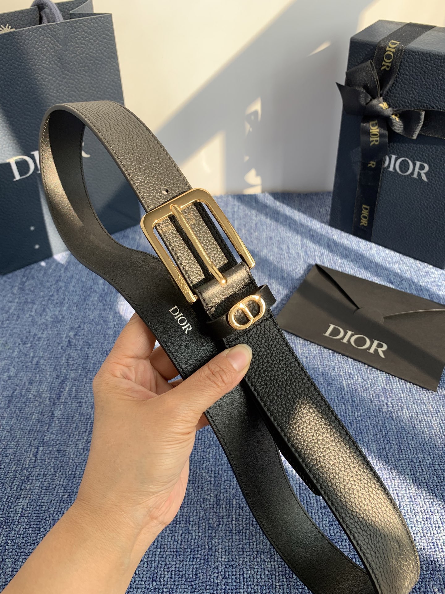 采用黑色粒面牛皮革精心制作，饰以镌刻有 Dior 的针扣和黑色金属覆层铜合金 CD Icon 标志腰带环