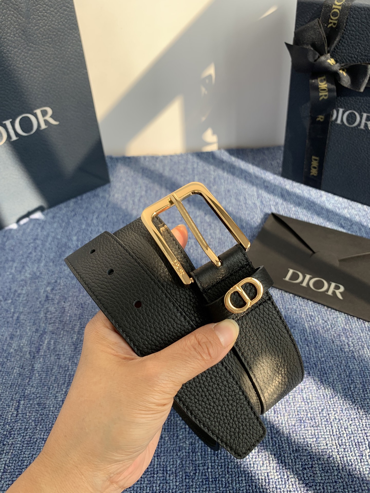 采用黑色粒面牛皮革精心制作，饰以镌刻有 Dior 的针扣和黑色金属覆层铜合金 CD Icon 标志腰带环