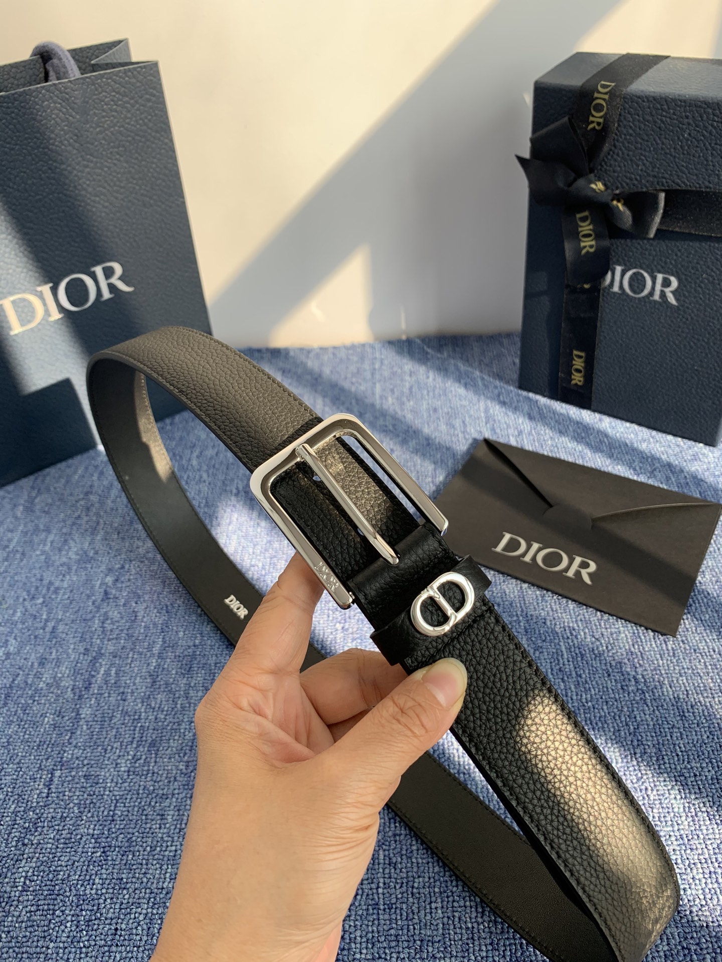 采用黑色粒面牛皮革精心制作，饰以镌刻有 Dior 的针扣和黑色金属覆层铜合金 CD Icon 标志腰带环