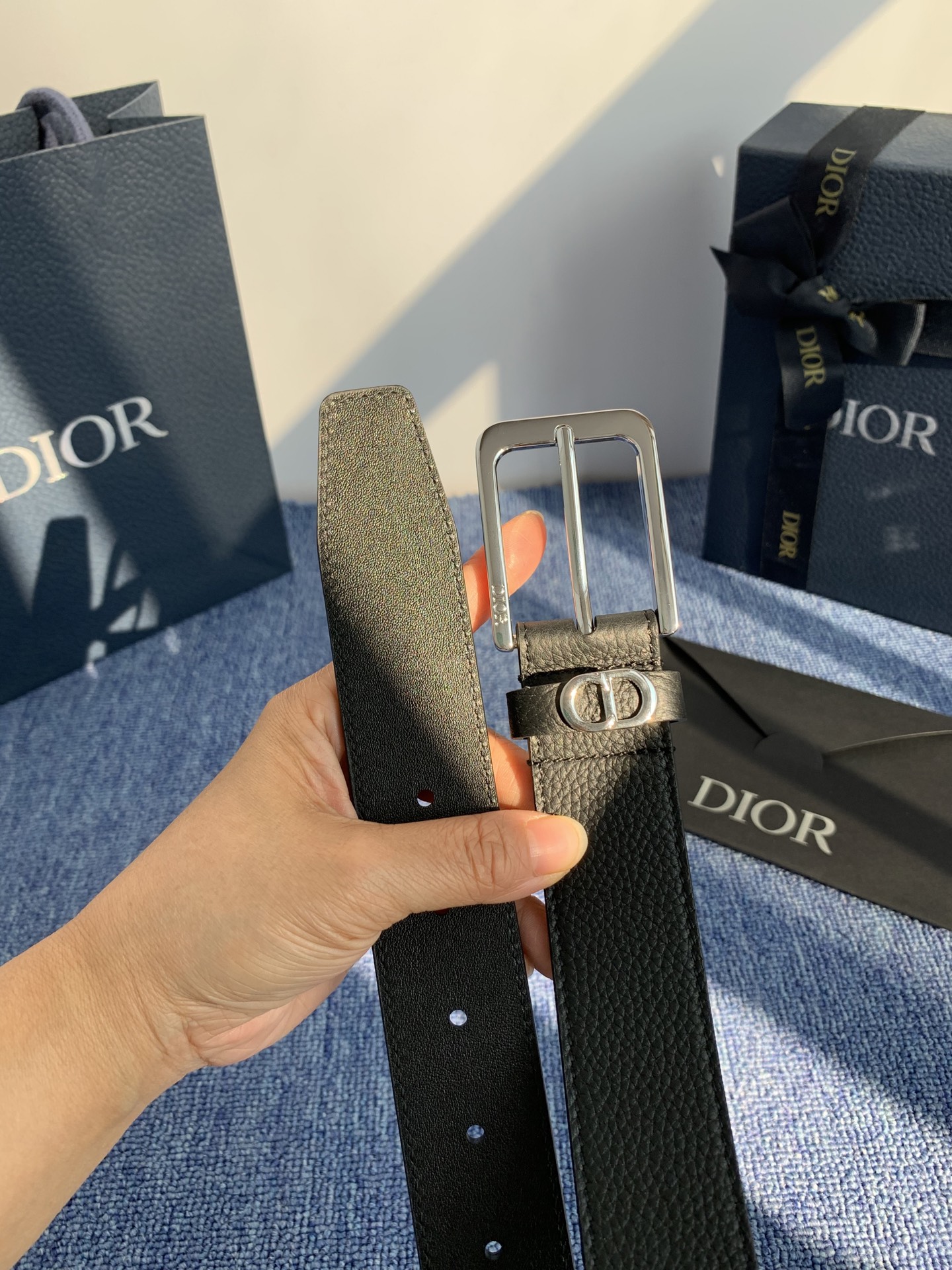 采用黑色粒面牛皮革精心制作，饰以镌刻有 Dior 的针扣和黑色金属覆层铜合金 CD Icon 标志腰带环