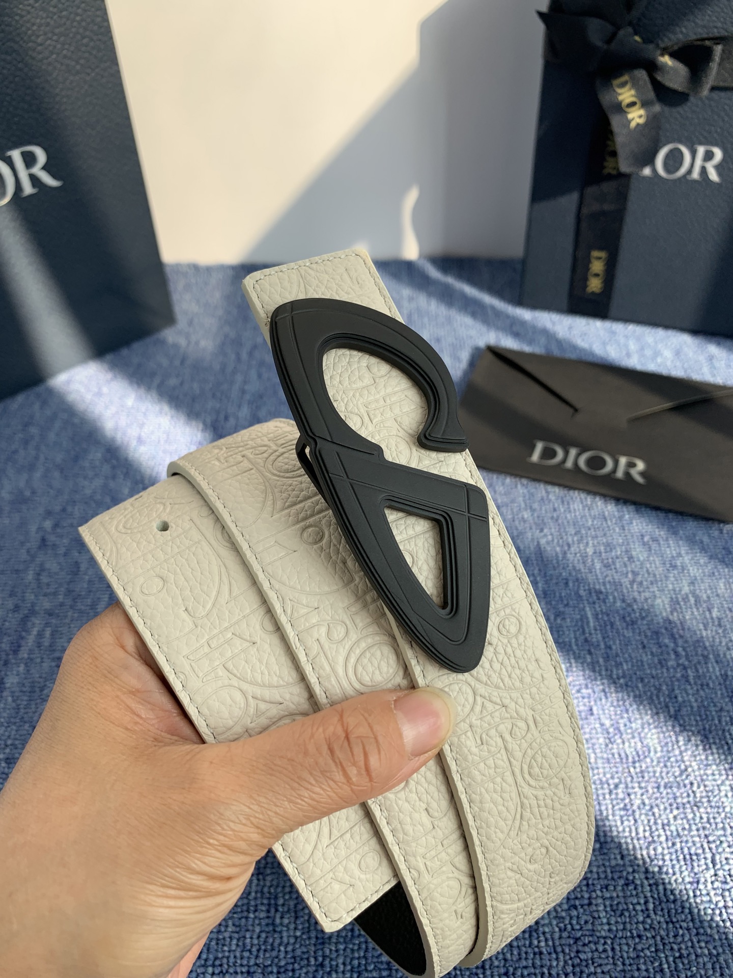 采用黑色粒面牛皮革精心制作，饰以镌刻有 Dior 的针扣和黑色金属覆层铜合金 CD Icon 标志腰带环