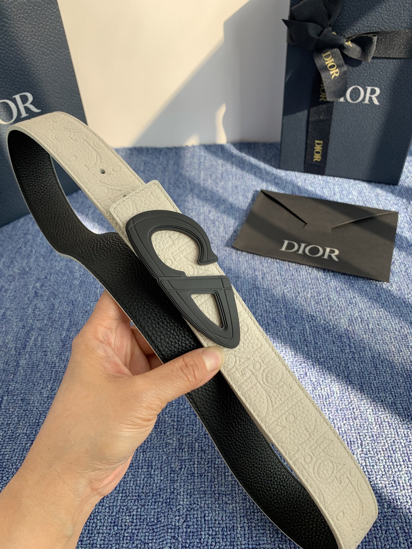 采用黑色粒面牛皮革精心制作，饰以镌刻有 Dior 的针扣和黑色金属覆层铜合金 CD Icon 标志腰带环