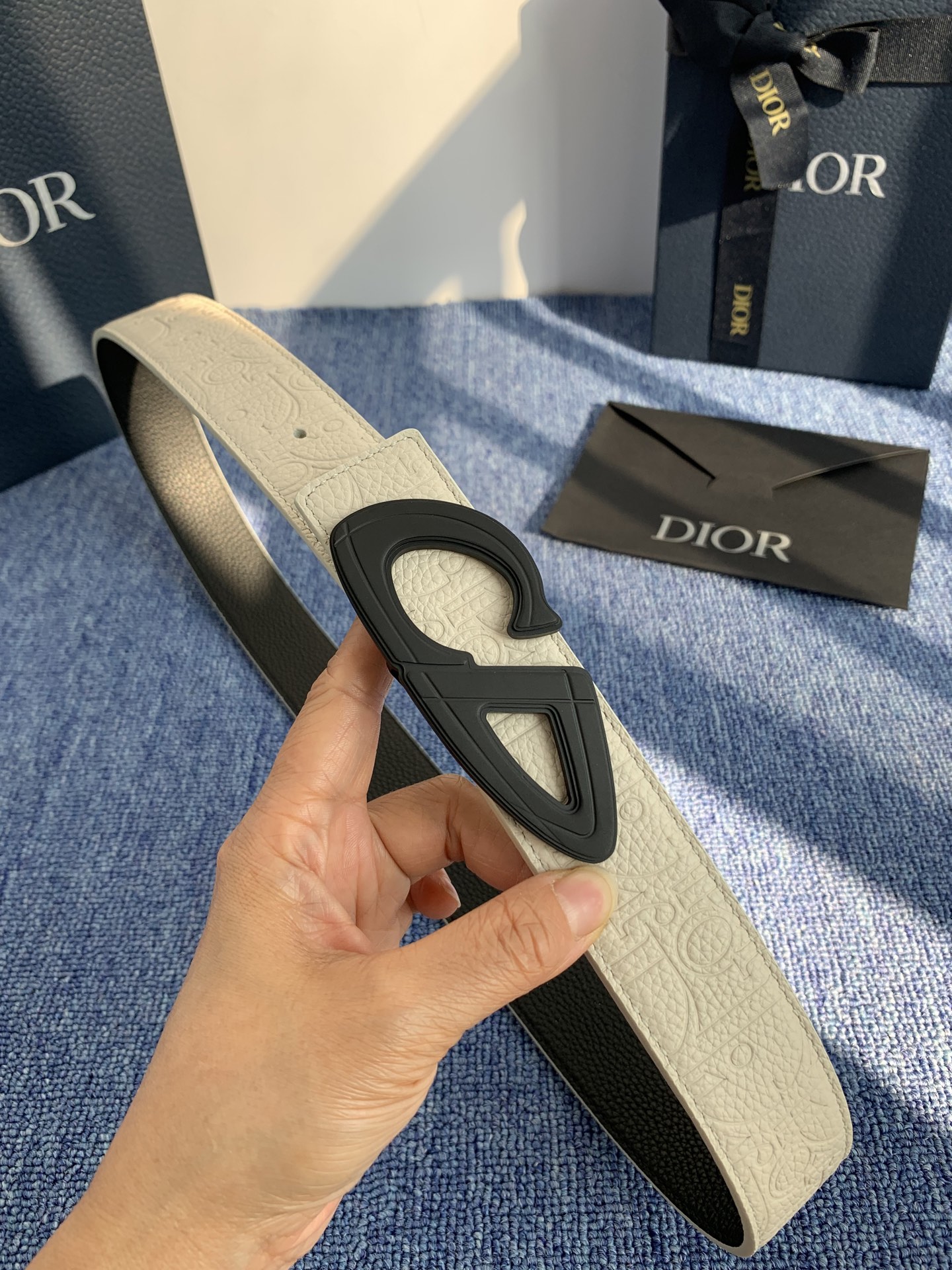 采用黑色粒面牛皮革精心制作，饰以镌刻有 Dior 的针扣和黑色金属覆层铜合金 CD Icon 标志腰带环