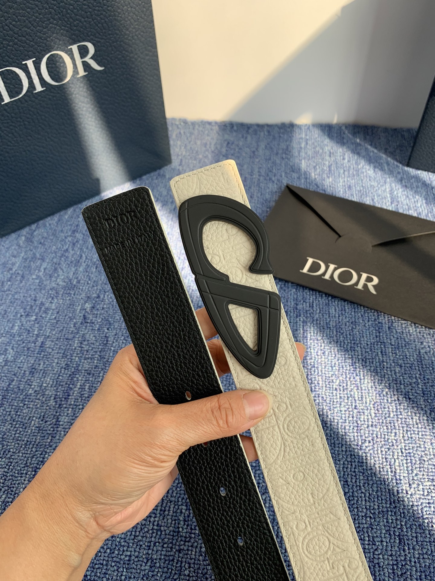 采用黑色粒面牛皮革精心制作，饰以镌刻有 Dior 的针扣和黑色金属覆层铜合金 CD Icon 标志腰带环