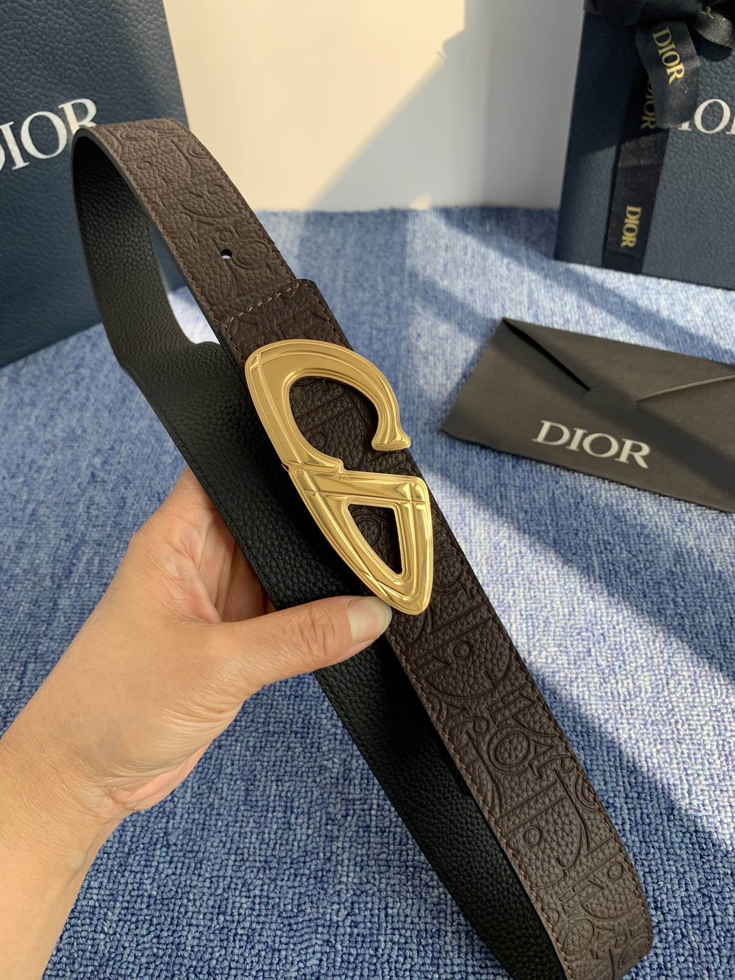 采用黑色粒面牛皮革精心制作，饰以镌刻有 Dior 的针扣和黑色金属覆层铜合金 CD Icon 标志腰带环