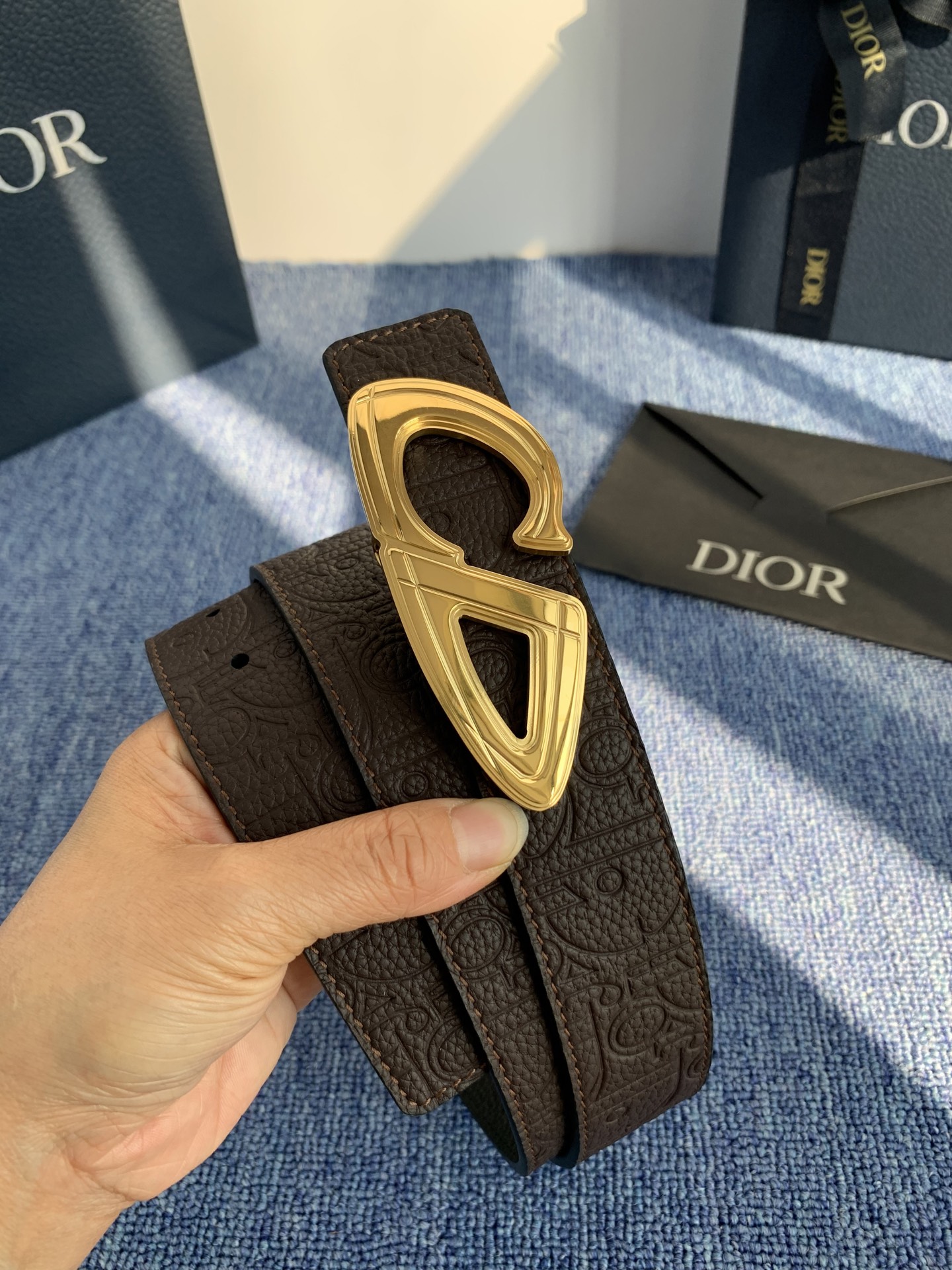 采用黑色粒面牛皮革精心制作，饰以镌刻有 Dior 的针扣和黑色金属覆层铜合金 CD Icon 标志腰带环