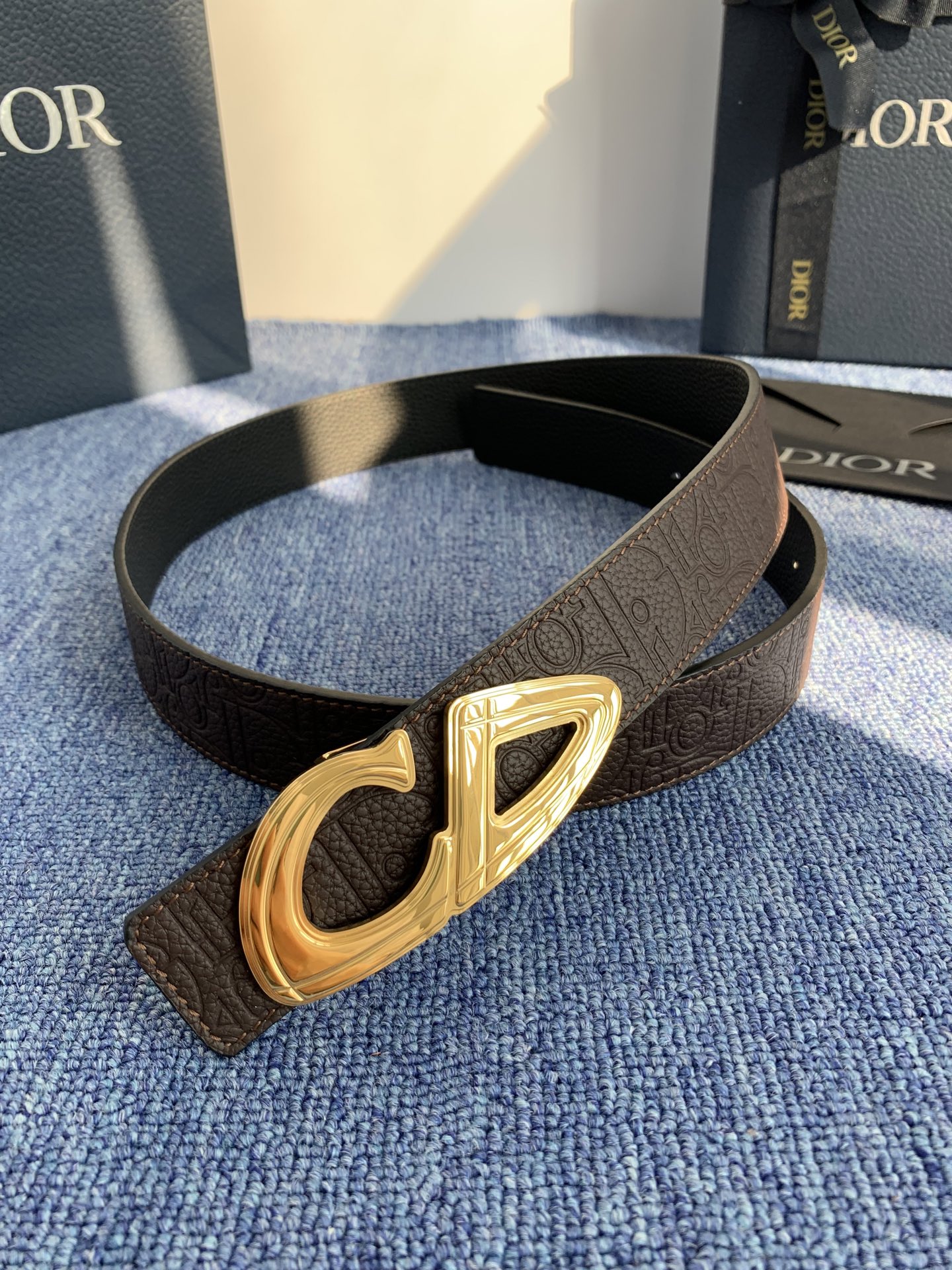 采用黑色粒面牛皮革精心制作，饰以镌刻有 Dior 的针扣和黑色金属覆层铜合金 CD Icon 标志腰带环