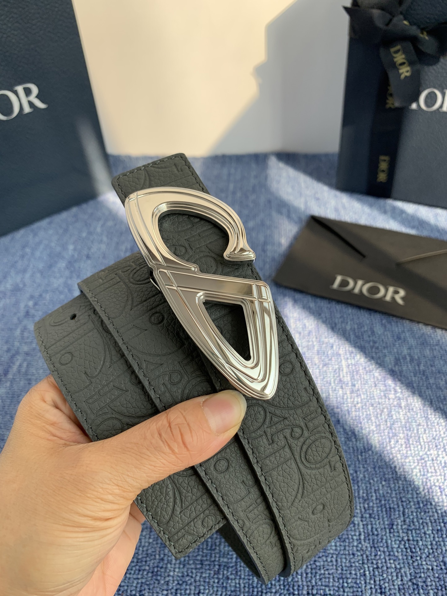 采用黑色粒面牛皮革精心制作，饰以镌刻有 Dior 的针扣和黑色金属覆层铜合金 CD Icon 标志腰带环